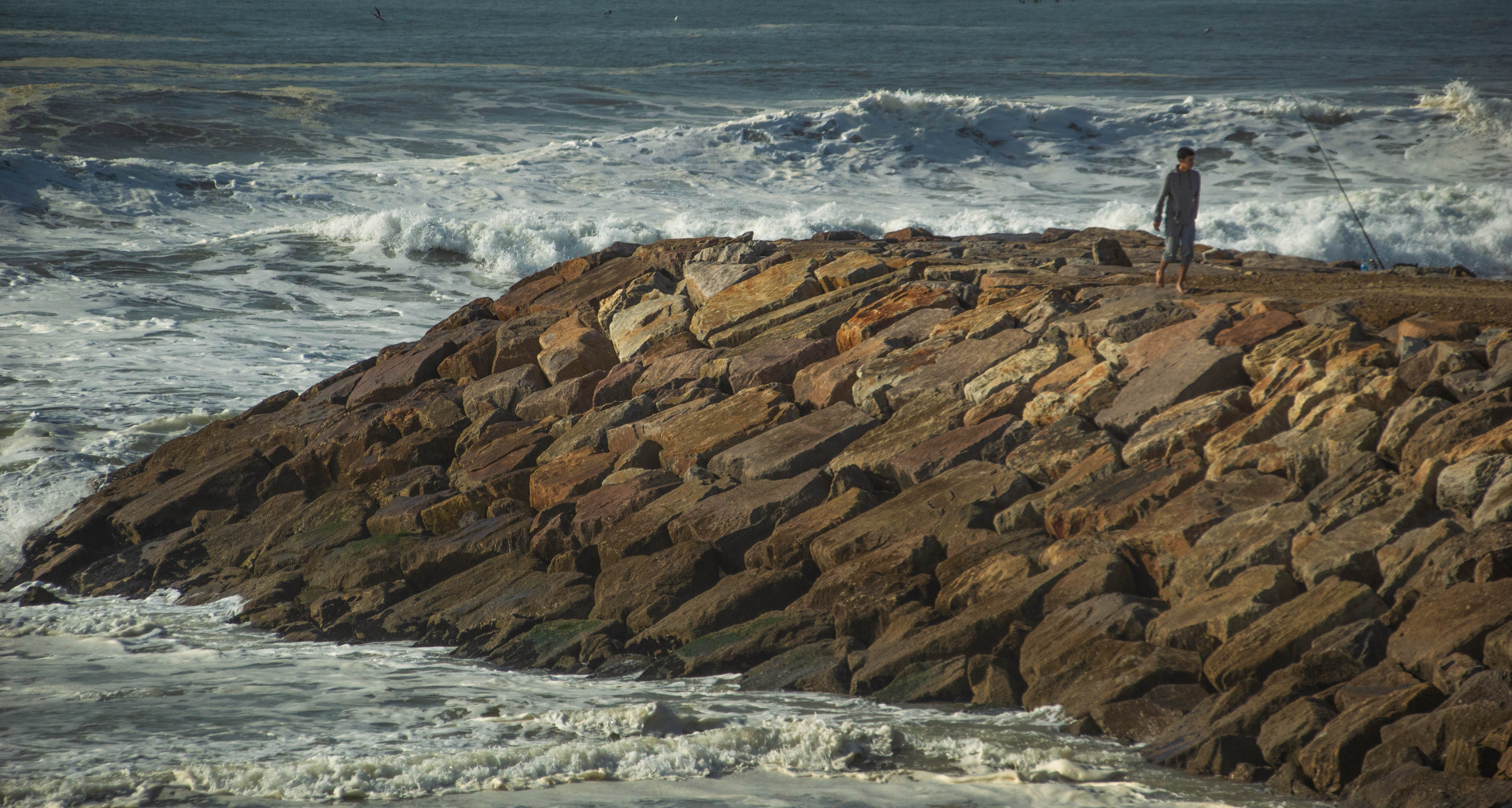 a person standing on a rocky shoreline