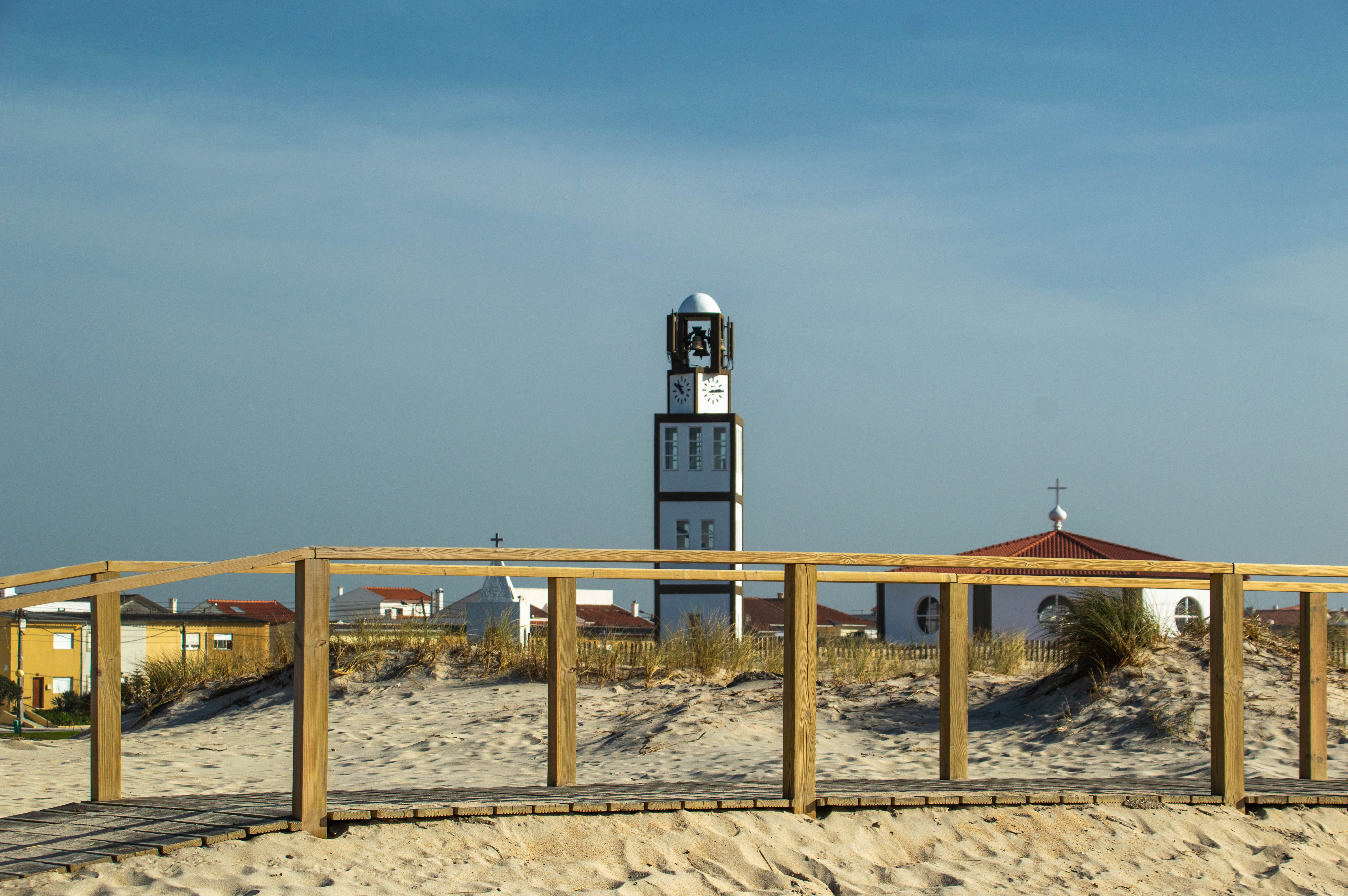 a wooden walkway leading towards a tall clock tower