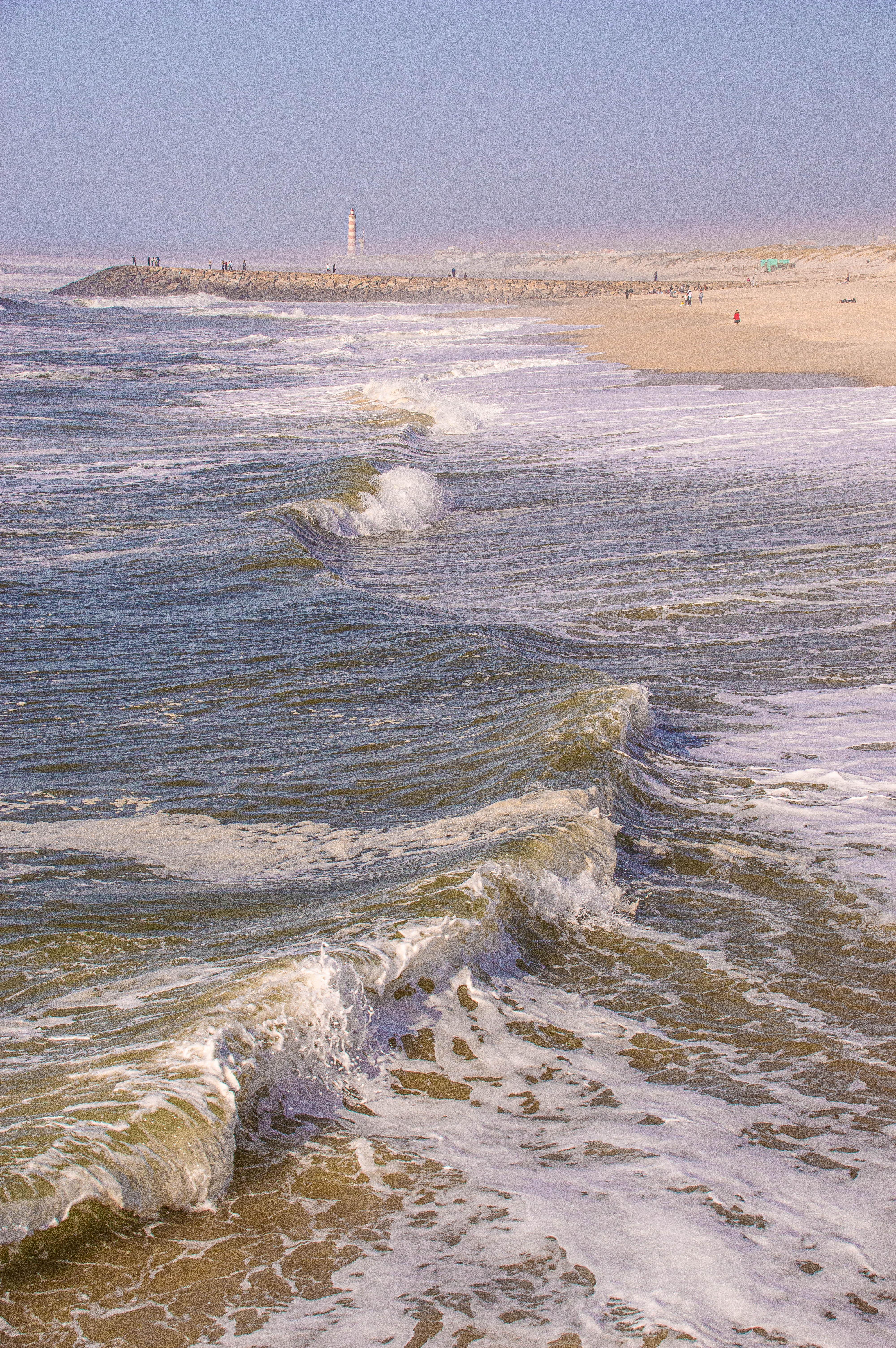 there is a lighthouse situated on a rocky outcrop extending into the ocean