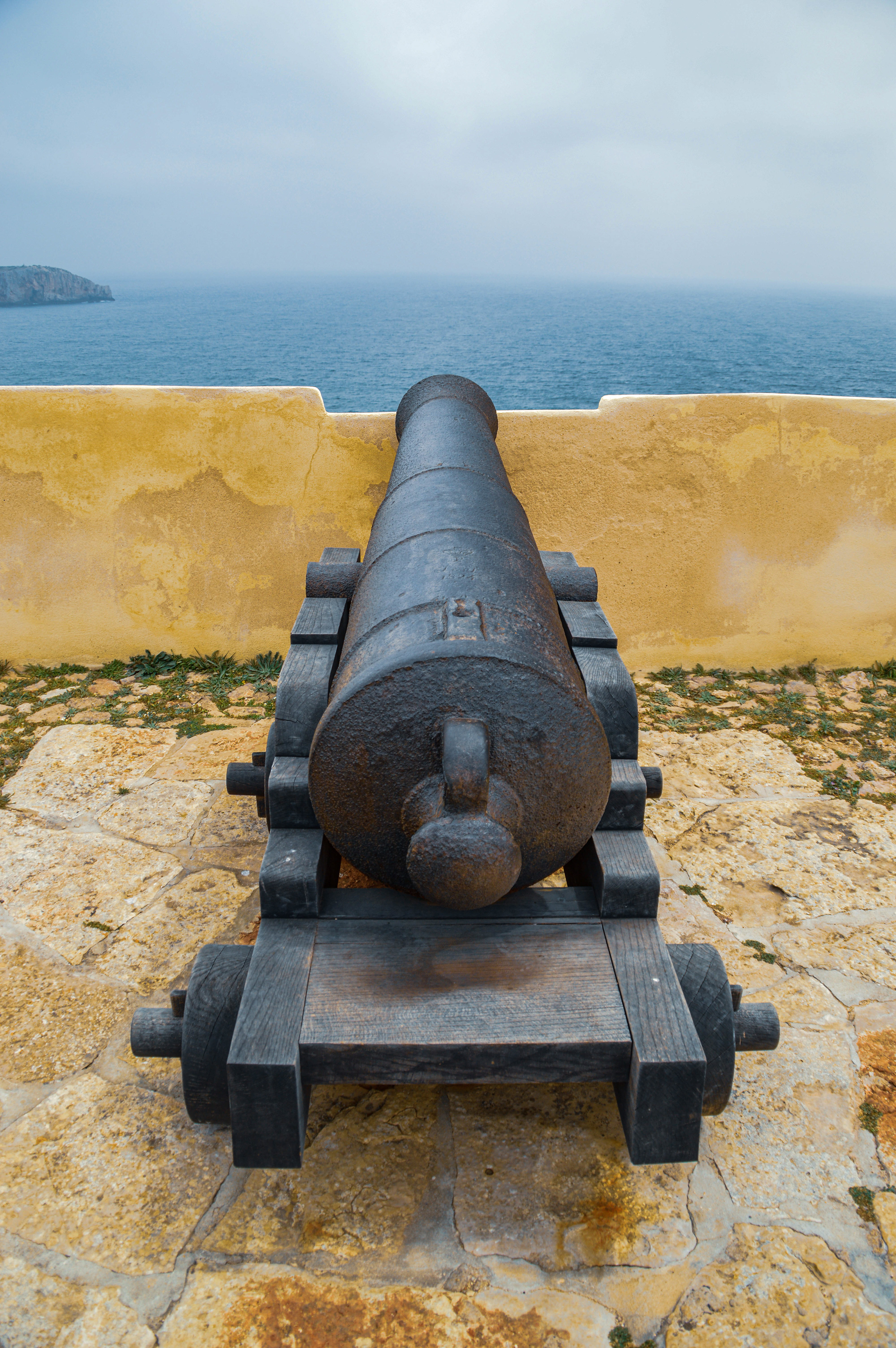 cannon mounted on a wooden carriage, positioned on a stone platform