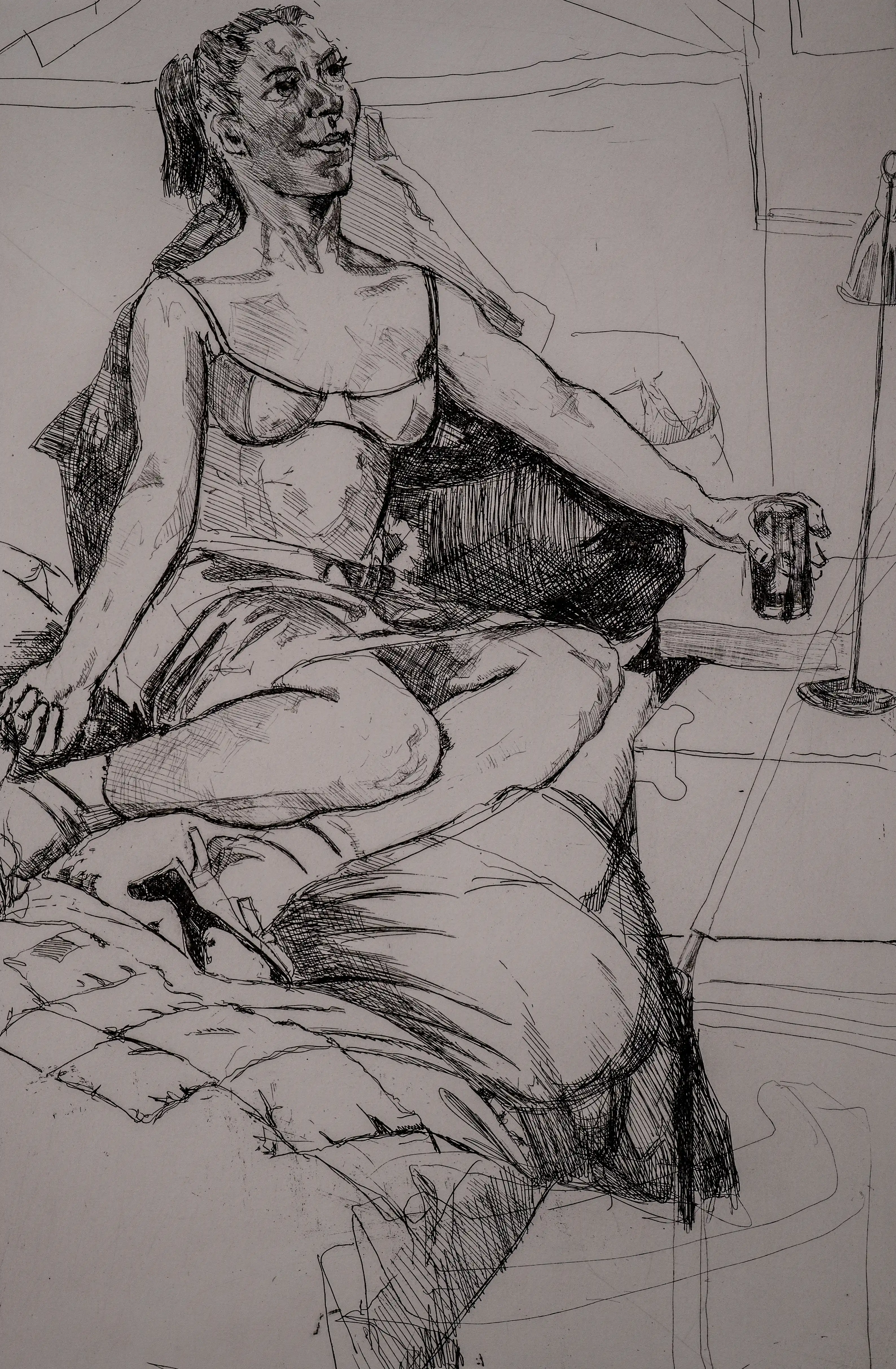 An etching of a woman in lingerie reclining on a bed, holding a drink, with the artist's signature, Paula Rego, visible.