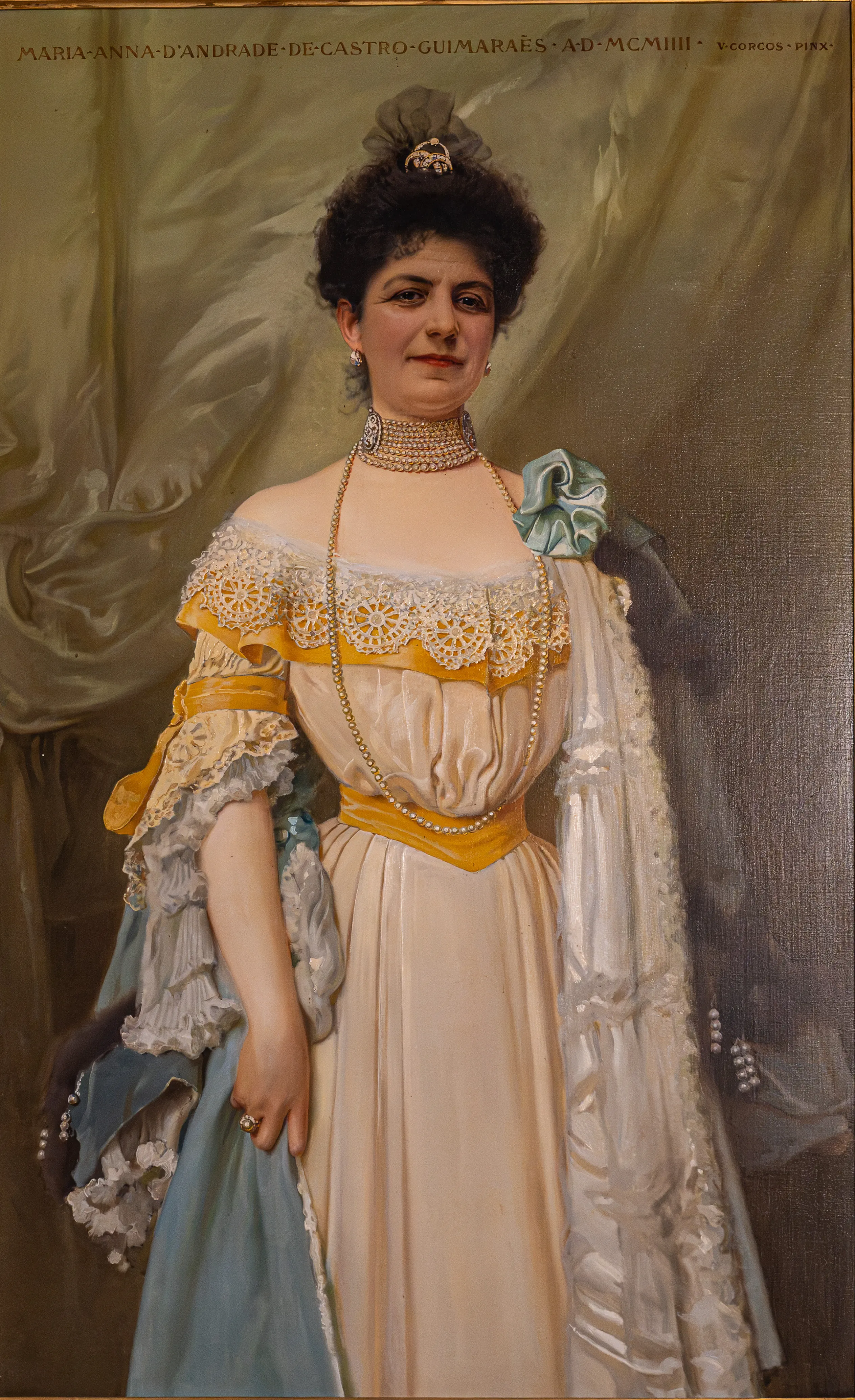 An oil painting in an ornate gold frame shows a woman with dark, upswept hair and a serious expression, wearing a formal cream-coloured dress with lace trim and a pale blue sash.