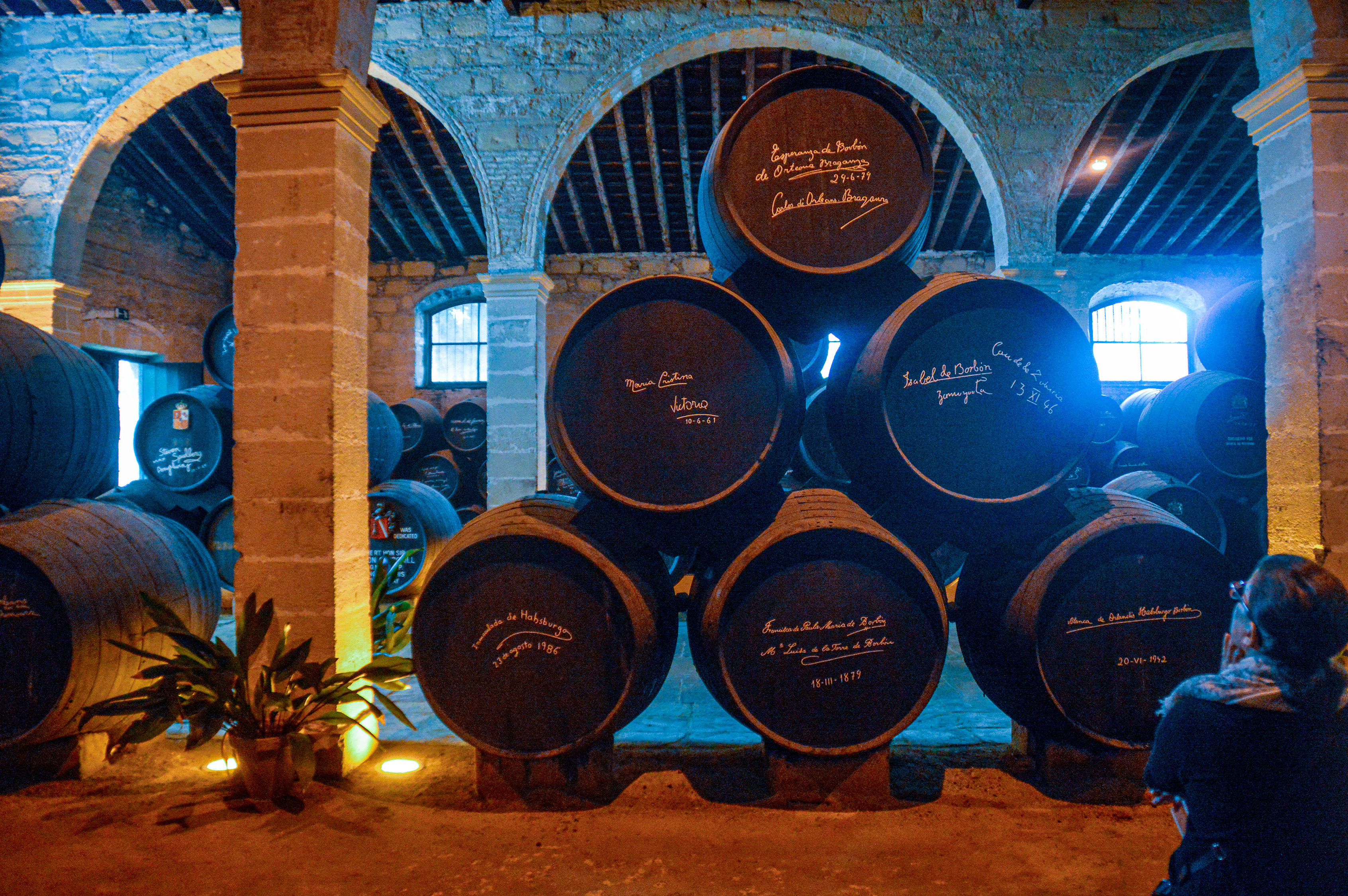 barrels stacked in an arched, stone-walled room