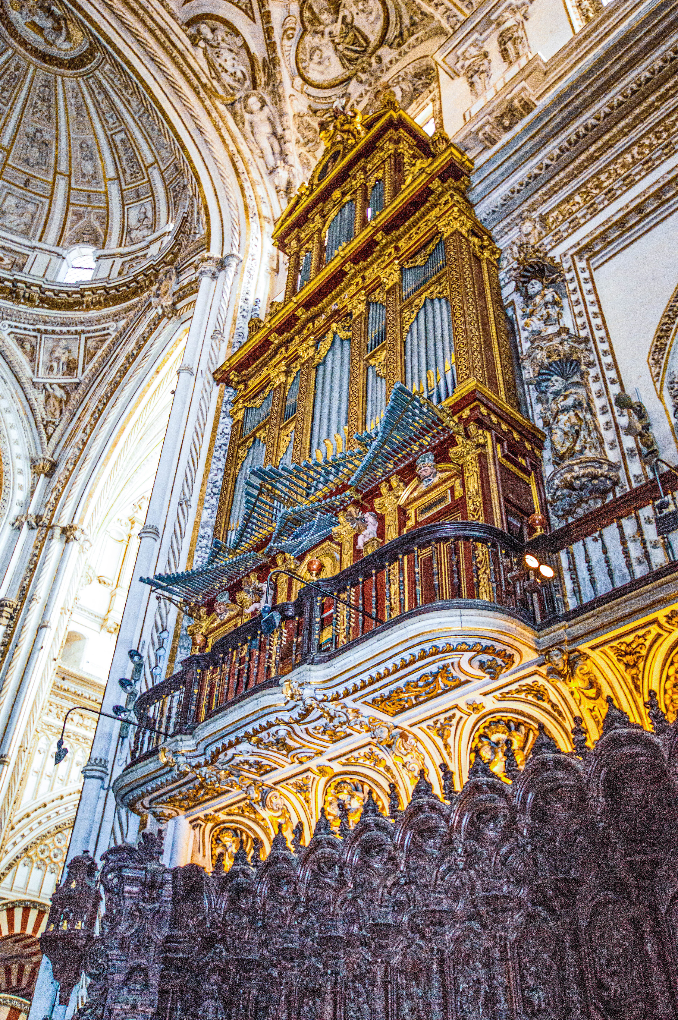 elaborately decorated pipe organ with gold and red accents