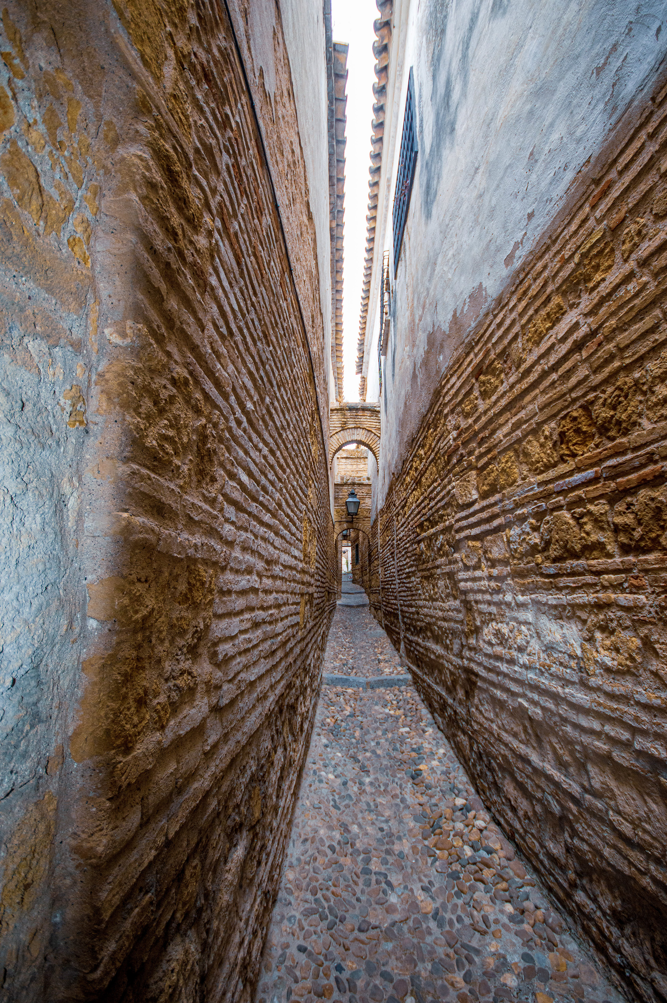 cobblestone alleyway with tall, closely set brick walls