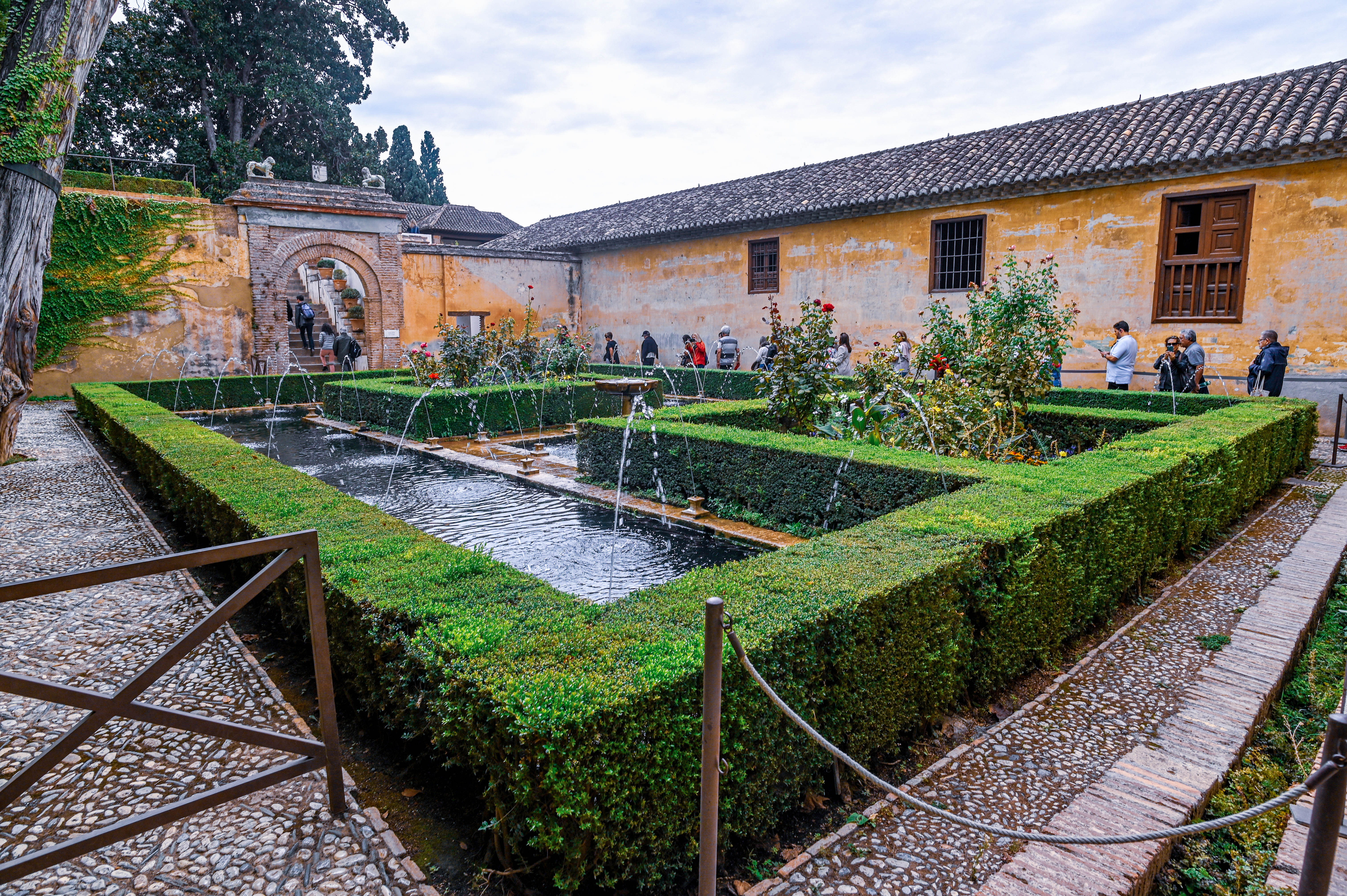 fountain surrounded by geometric hedges and water channels