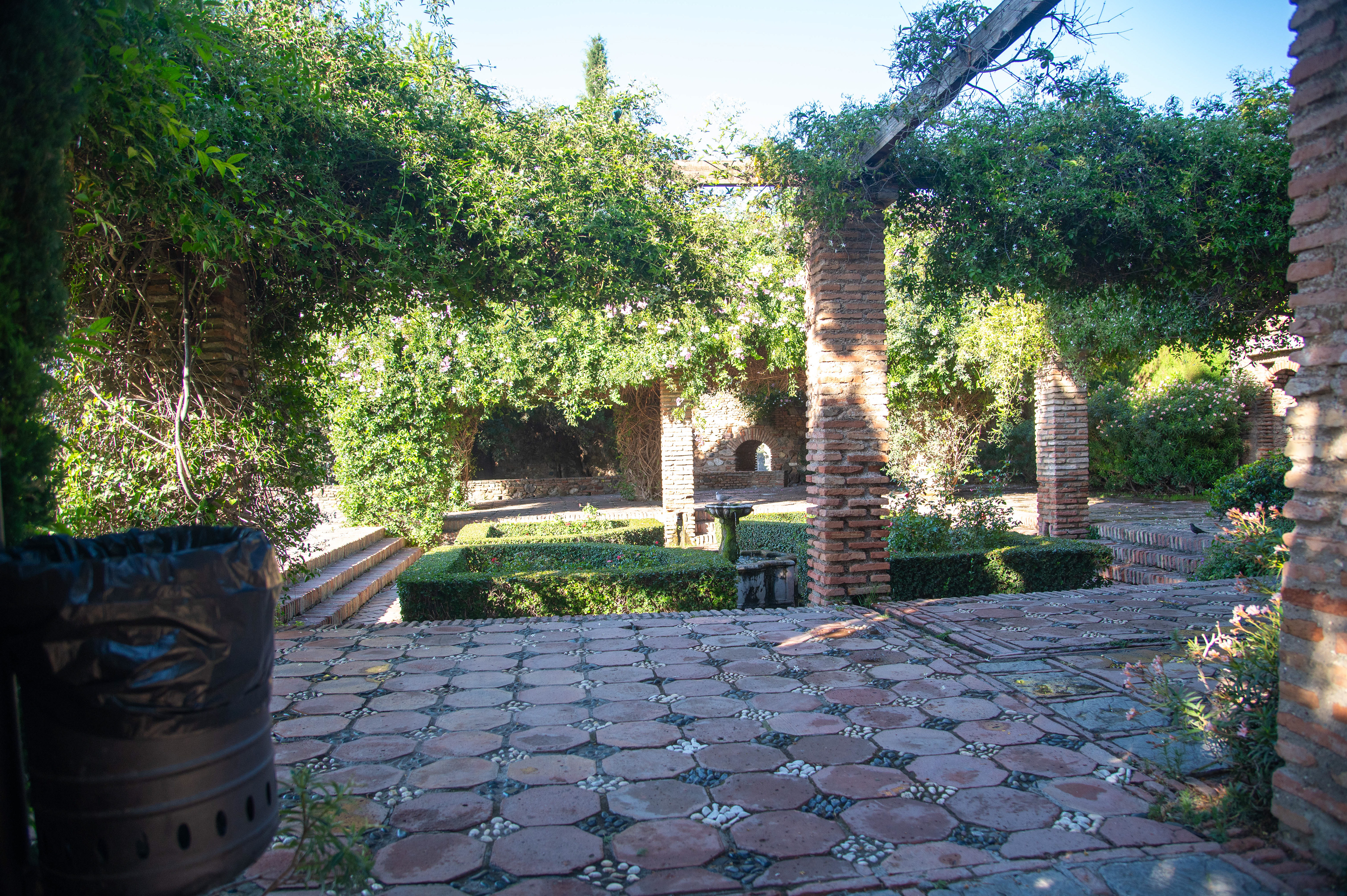 garden area with brick pathways and arches