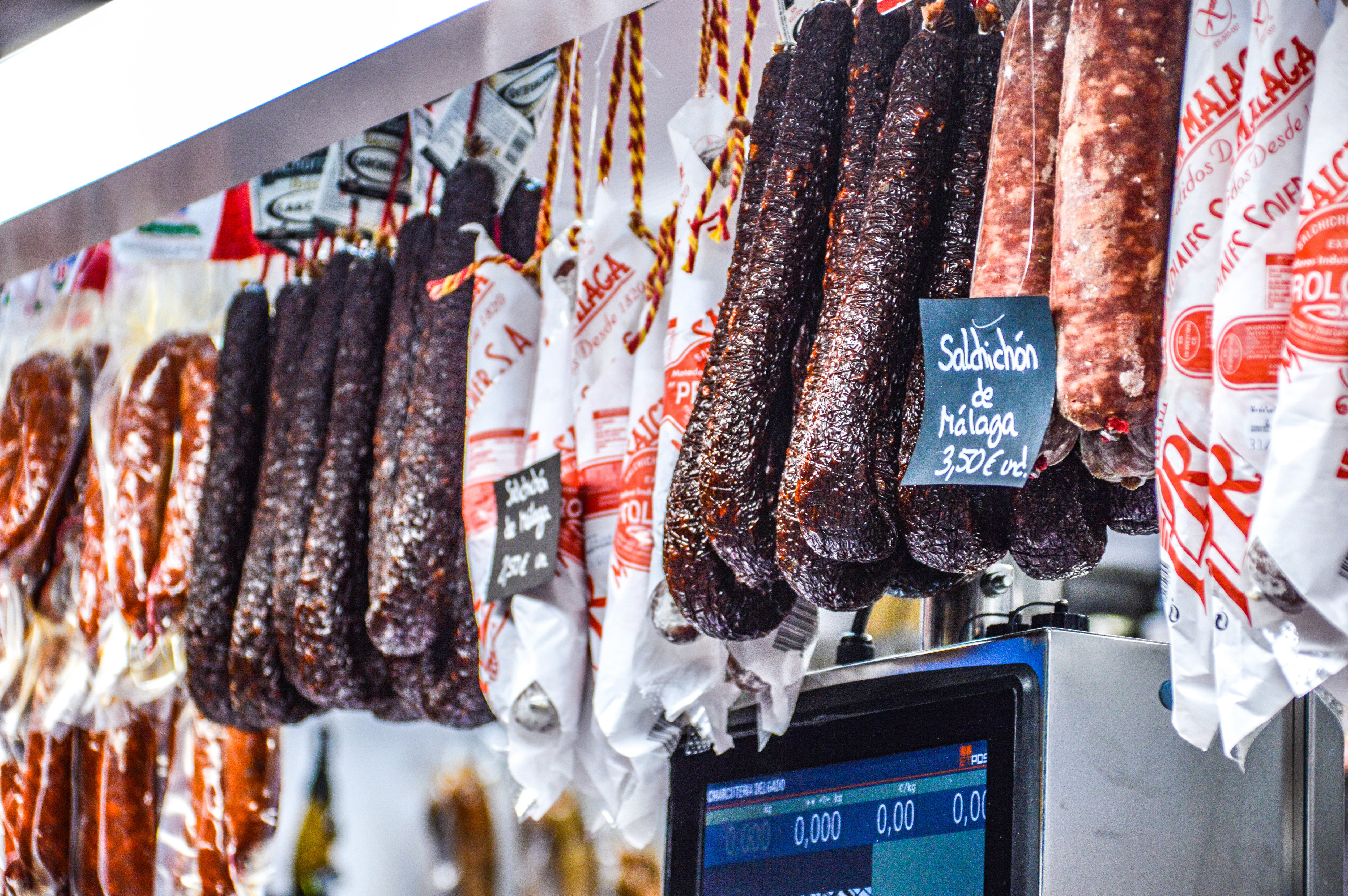 cured sausages hanging in a market or deli