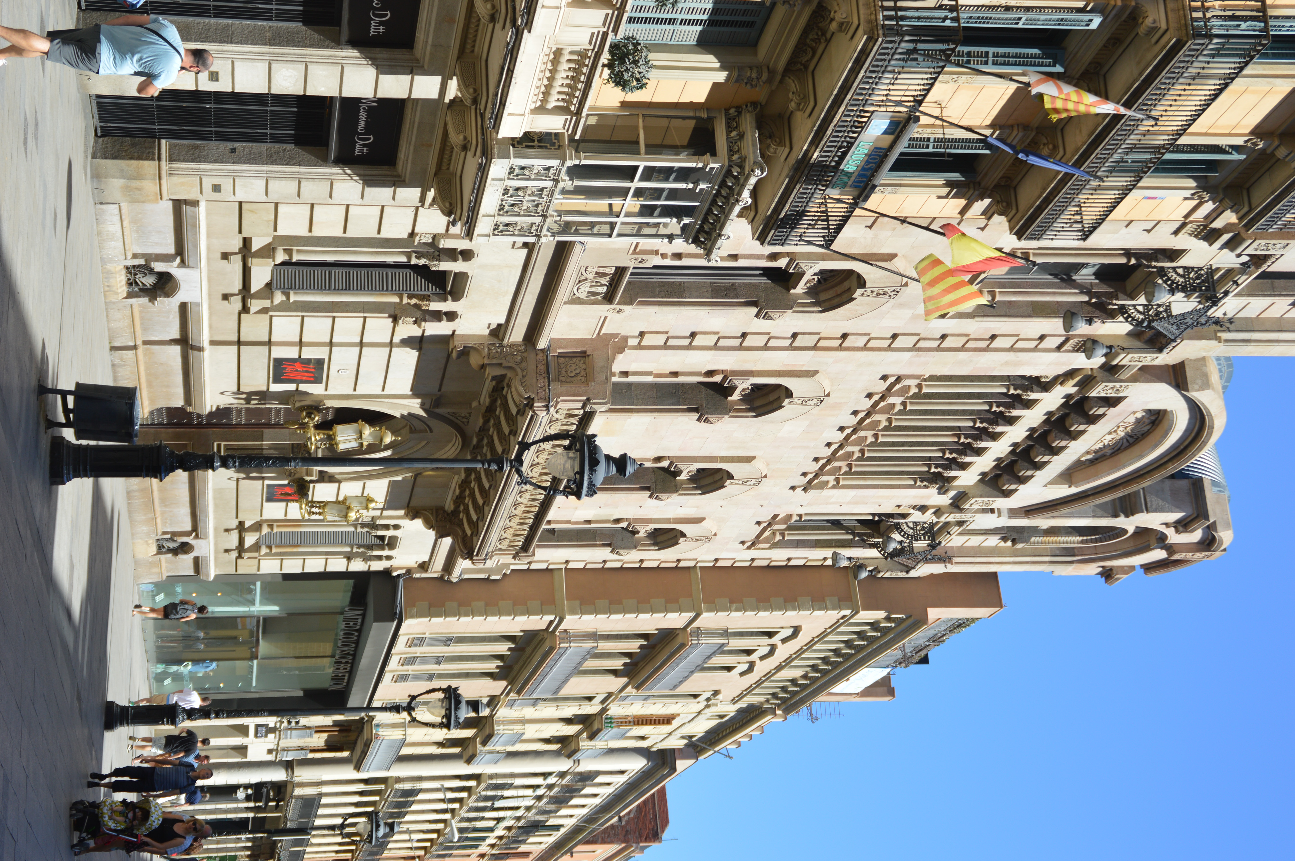 The architecture features intricate details, balconies, and flags