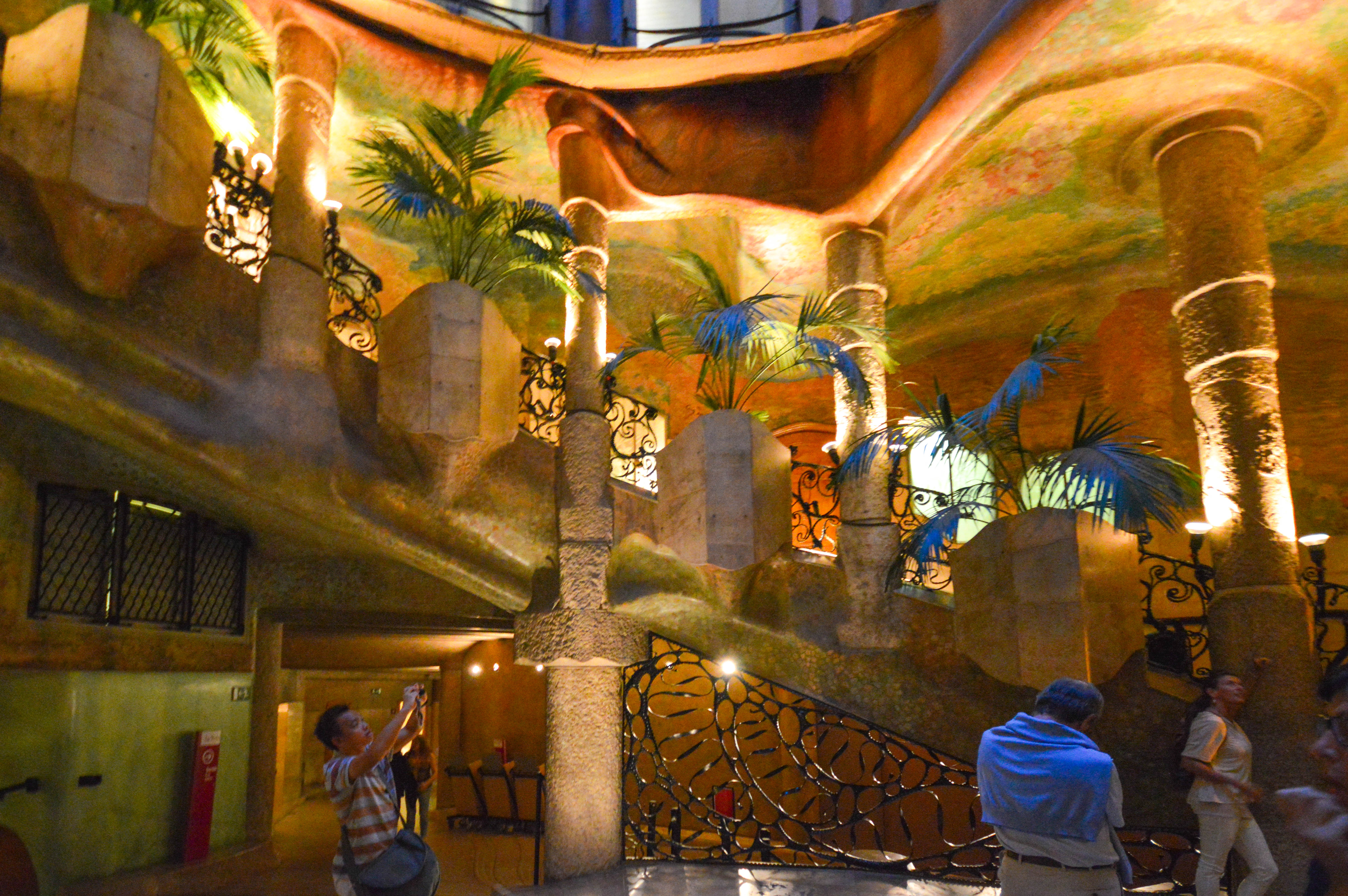 an interior space with a tropical theme, featuring palm trees and ornate iron railings