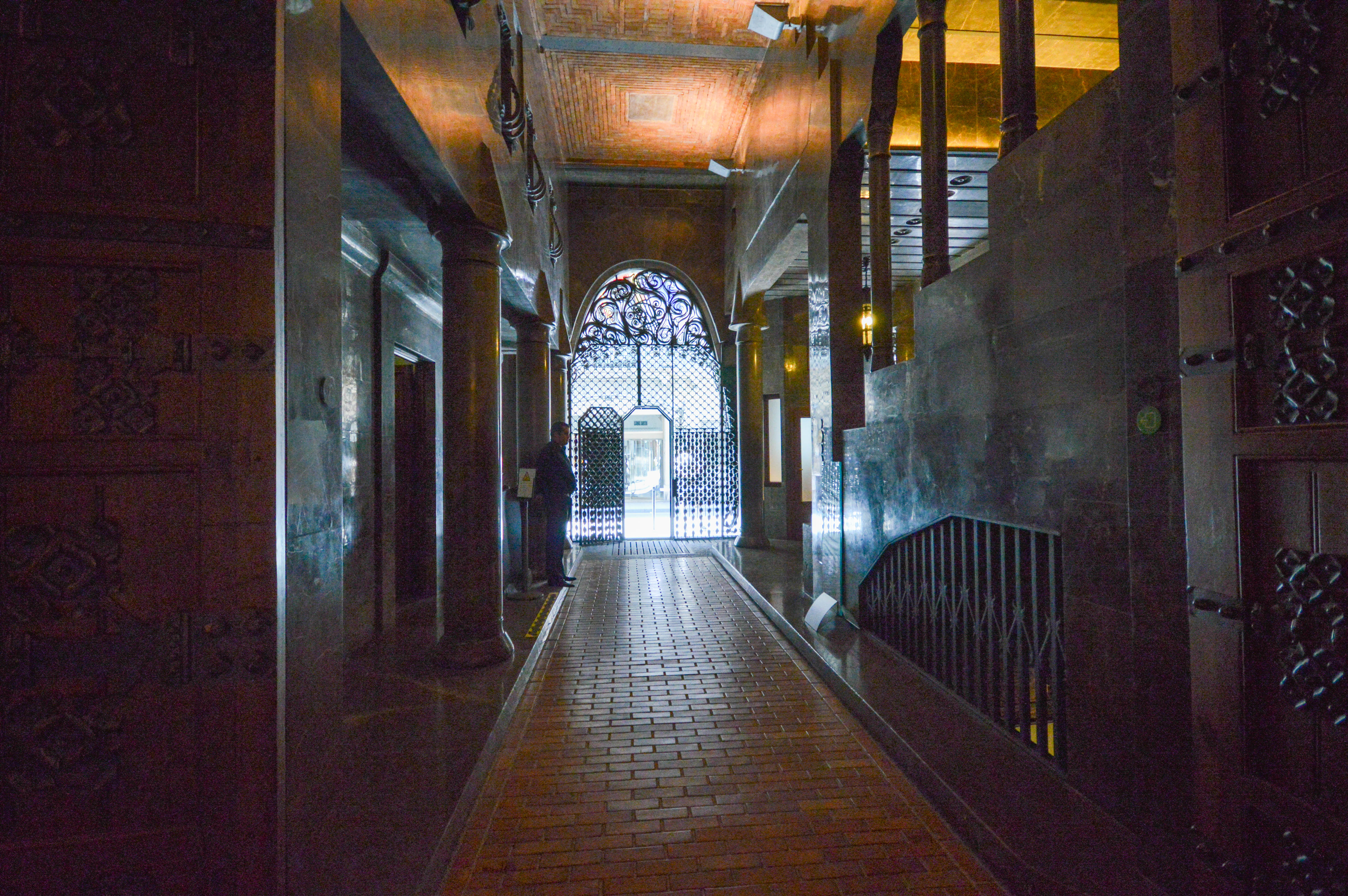 narrow hallway with a brick floor and stone walls