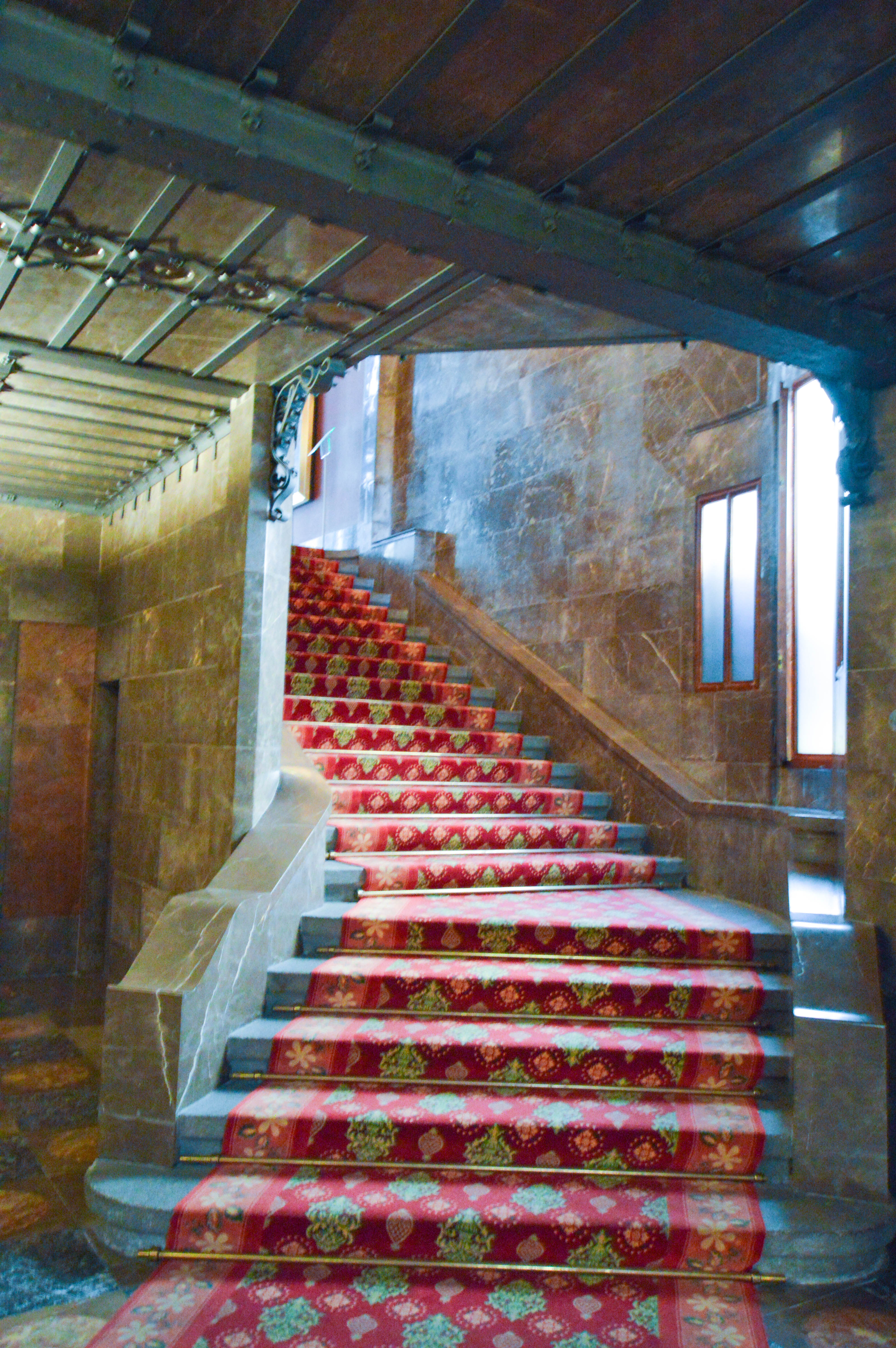 interior staircase with a red and floral patterned carpet