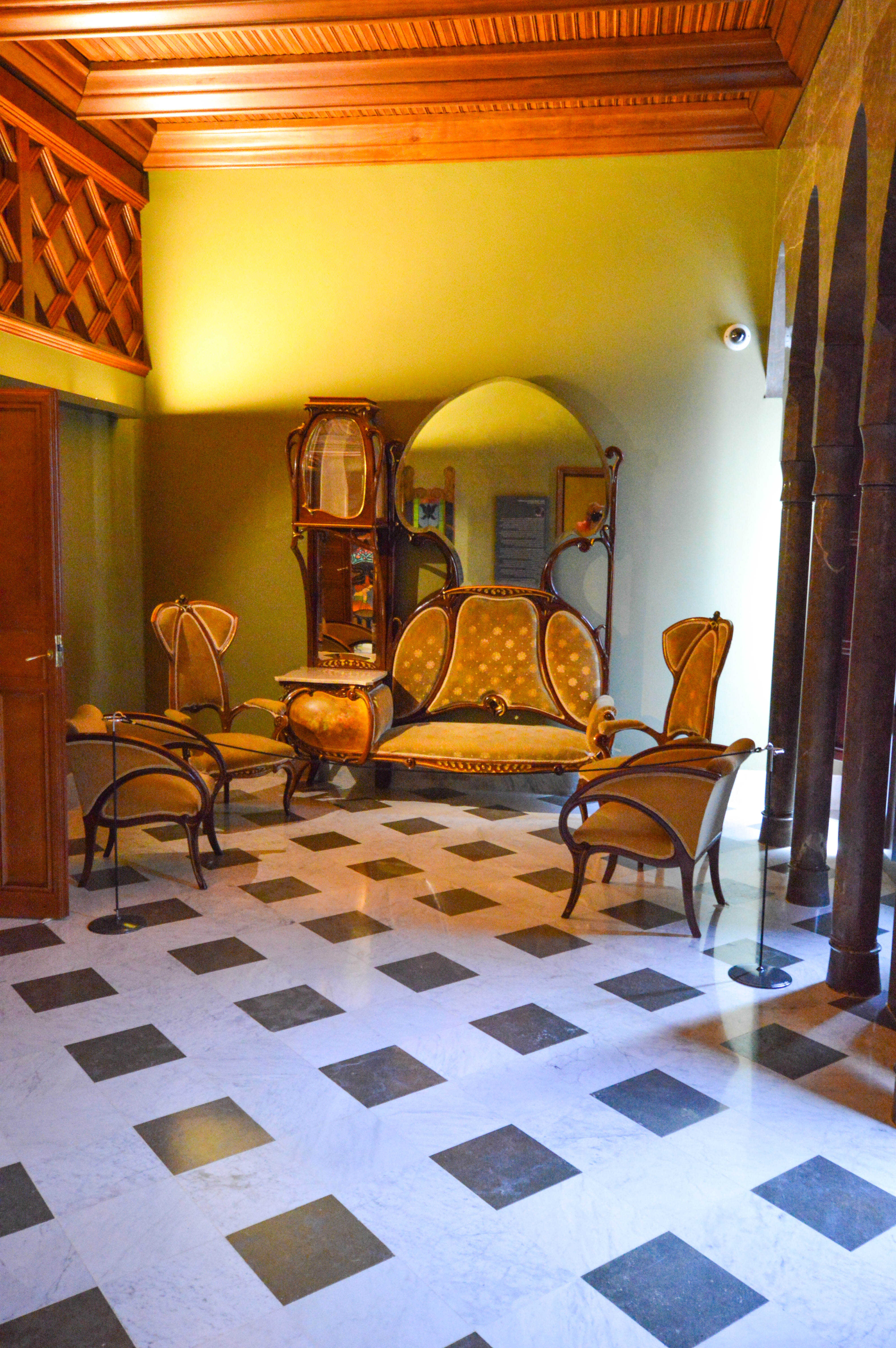 a large, ornate sofa, several chairs, and a cabinet with a mirror