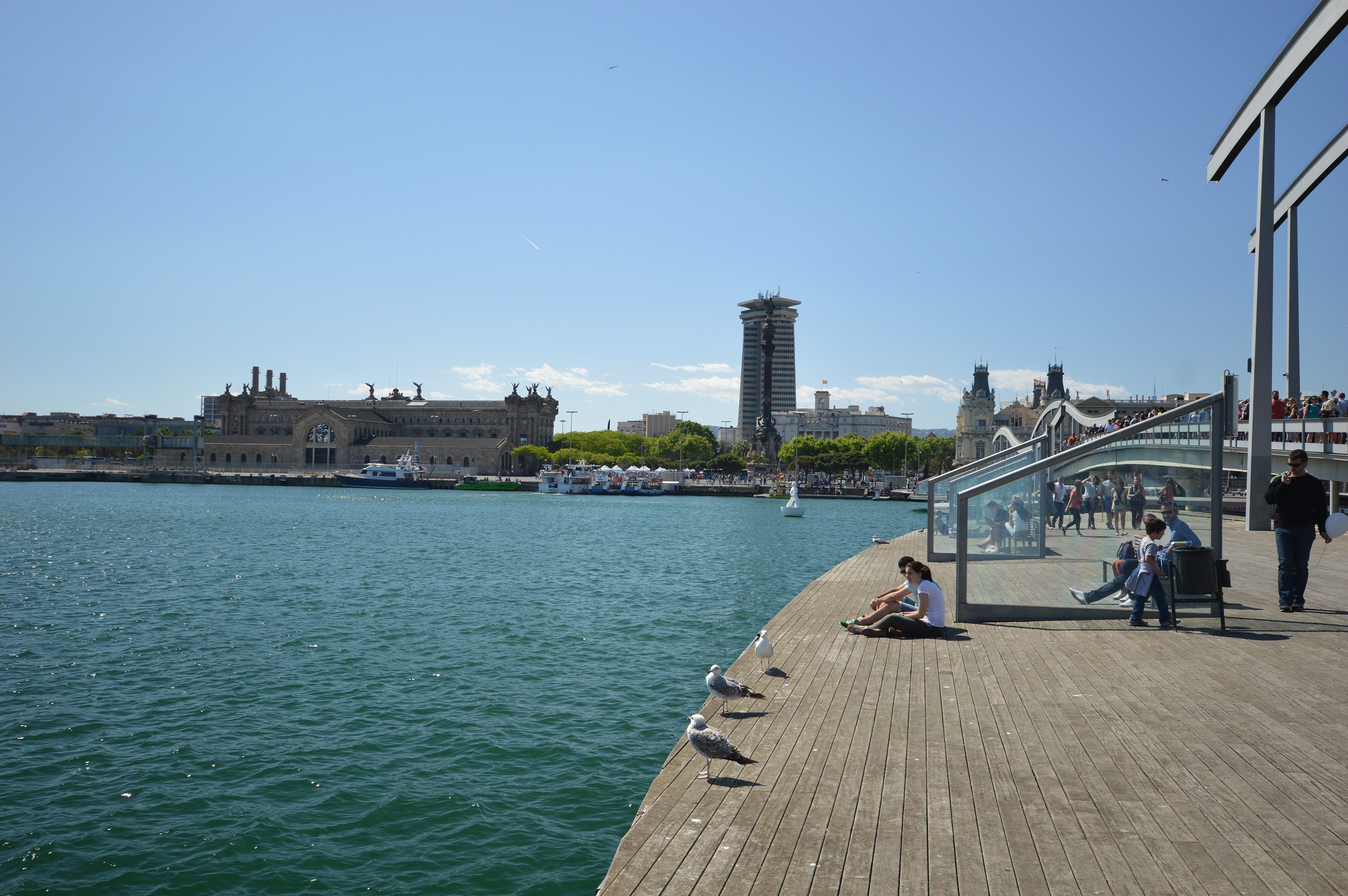 eople are seen relaxing and walking along the boardwalk