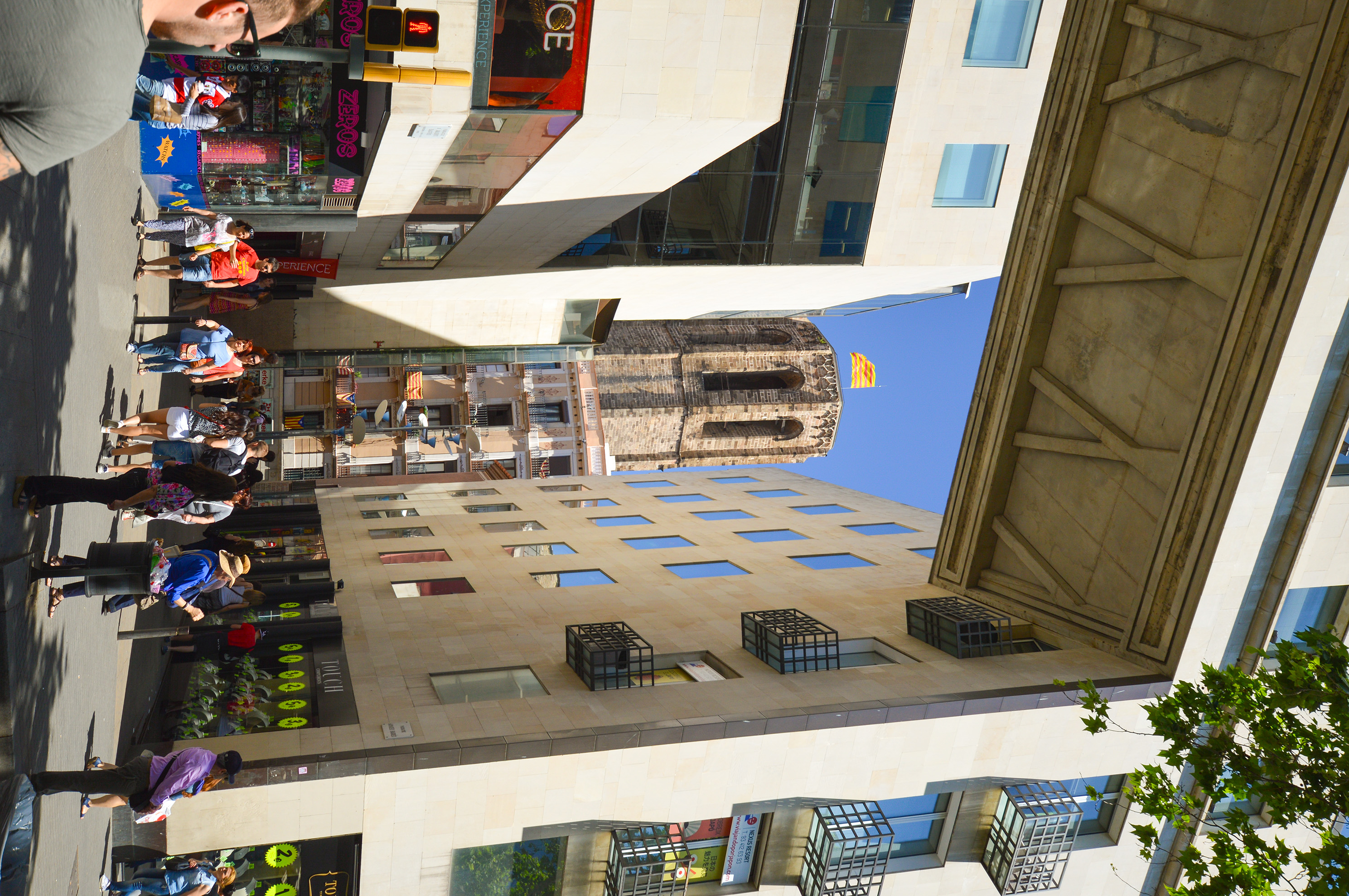 a narrow alleyway surrounded by modern buildings