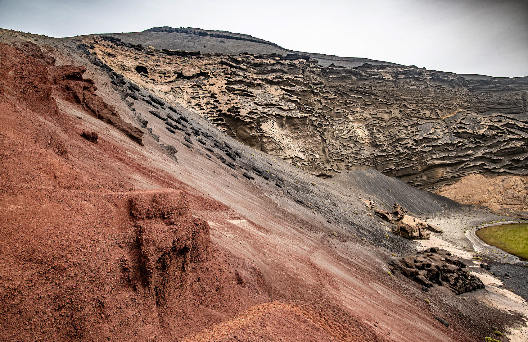 a rugged, layered hillside with a mix of red and gray hues
