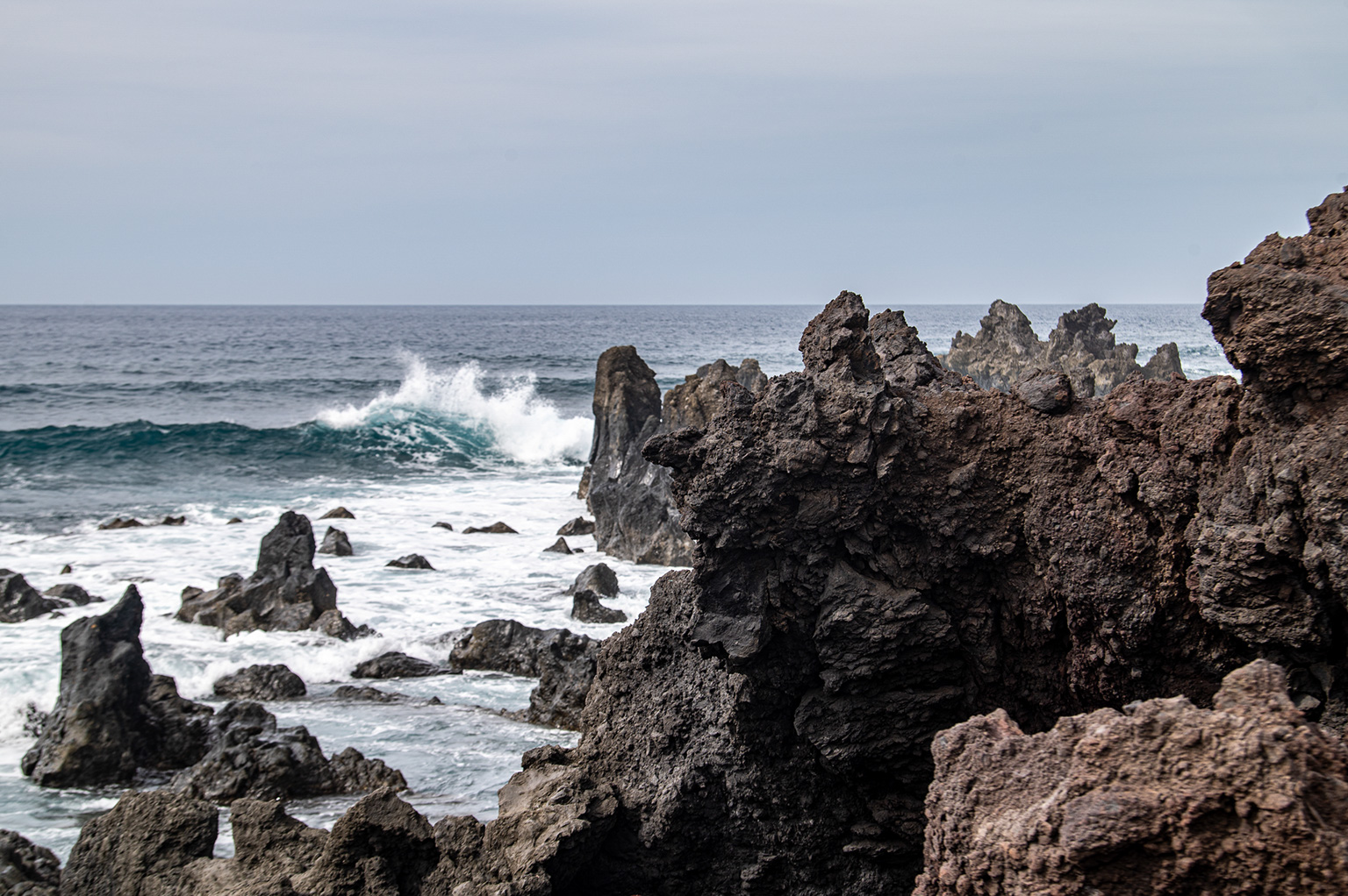 a rocky coastline with large, jagged rock formations extending into the ocean