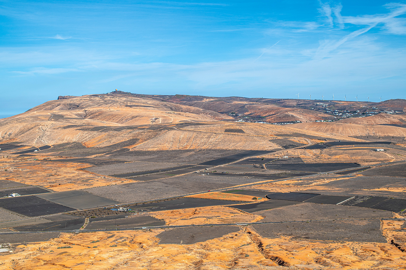 a vast, arid landscape with rolling hills and sparse vegetation