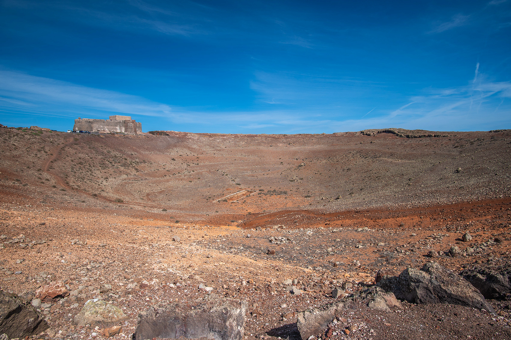 arid landscape with a clear blue sky. In the distance id Castillo Santa Bárbara