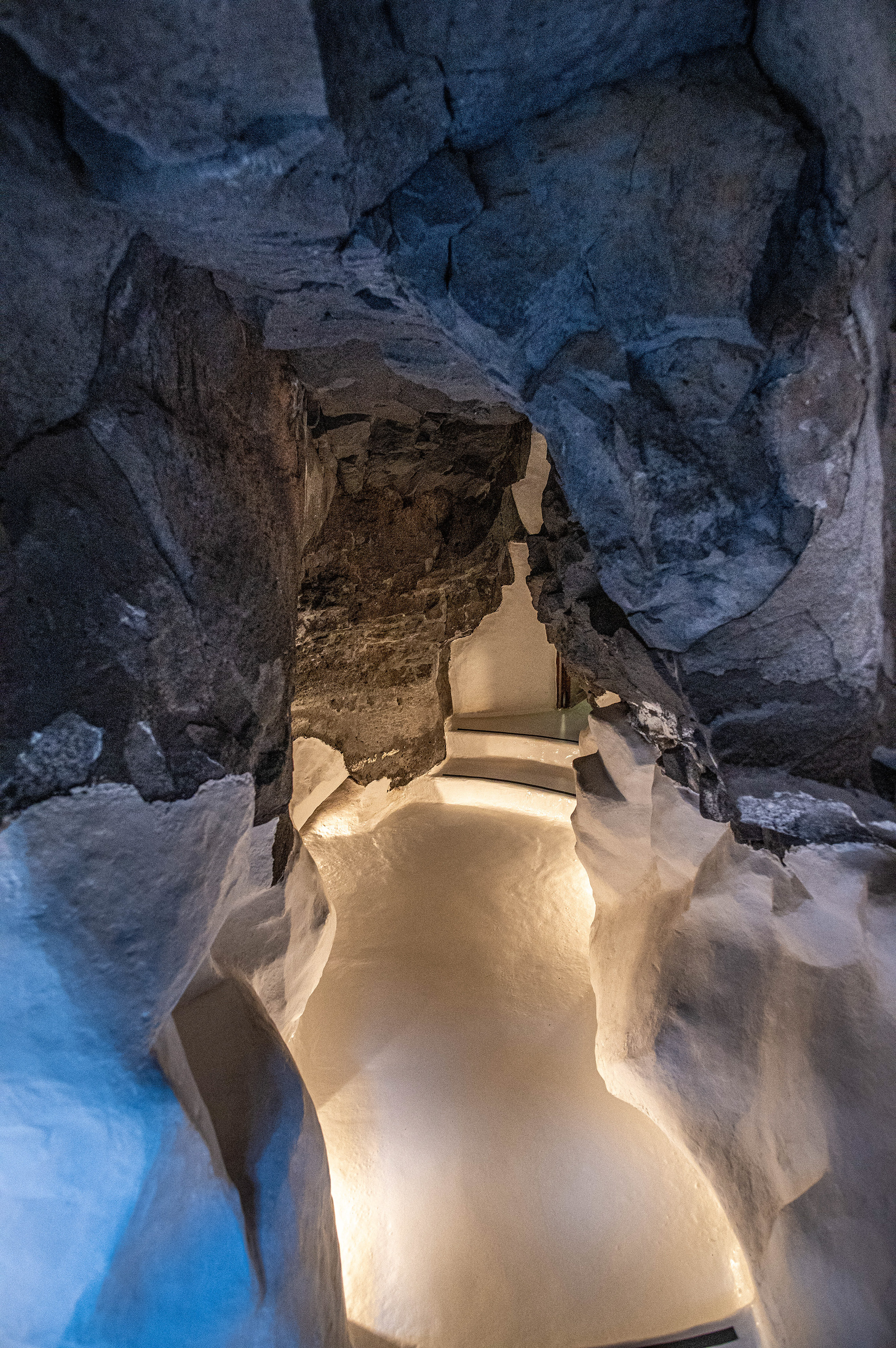 winding staircase descending into a rocky, cave-like structure