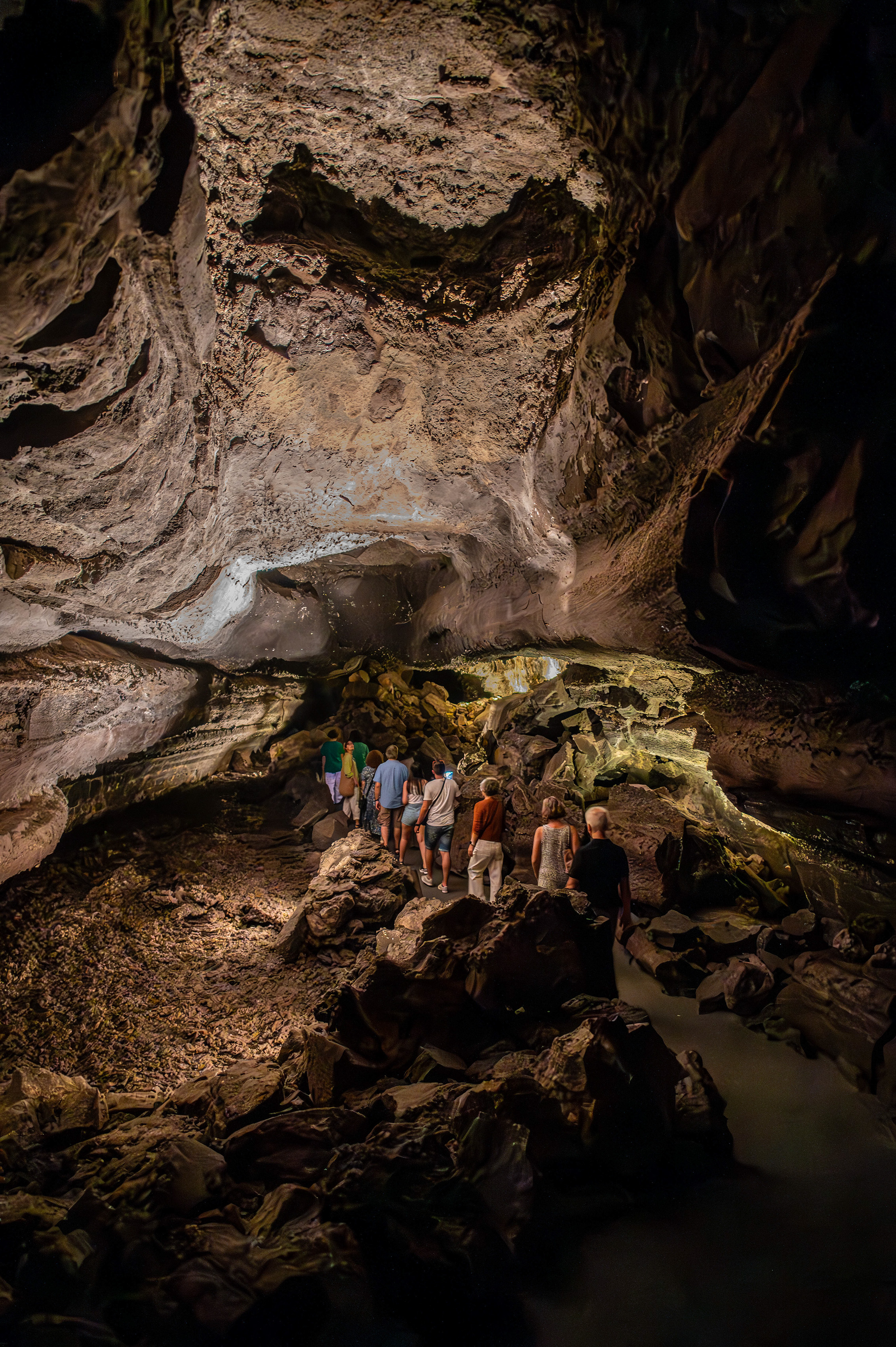 The cave has rough, rocky walls and is dimly lit, highlighting the natural formations and the rugged terrain