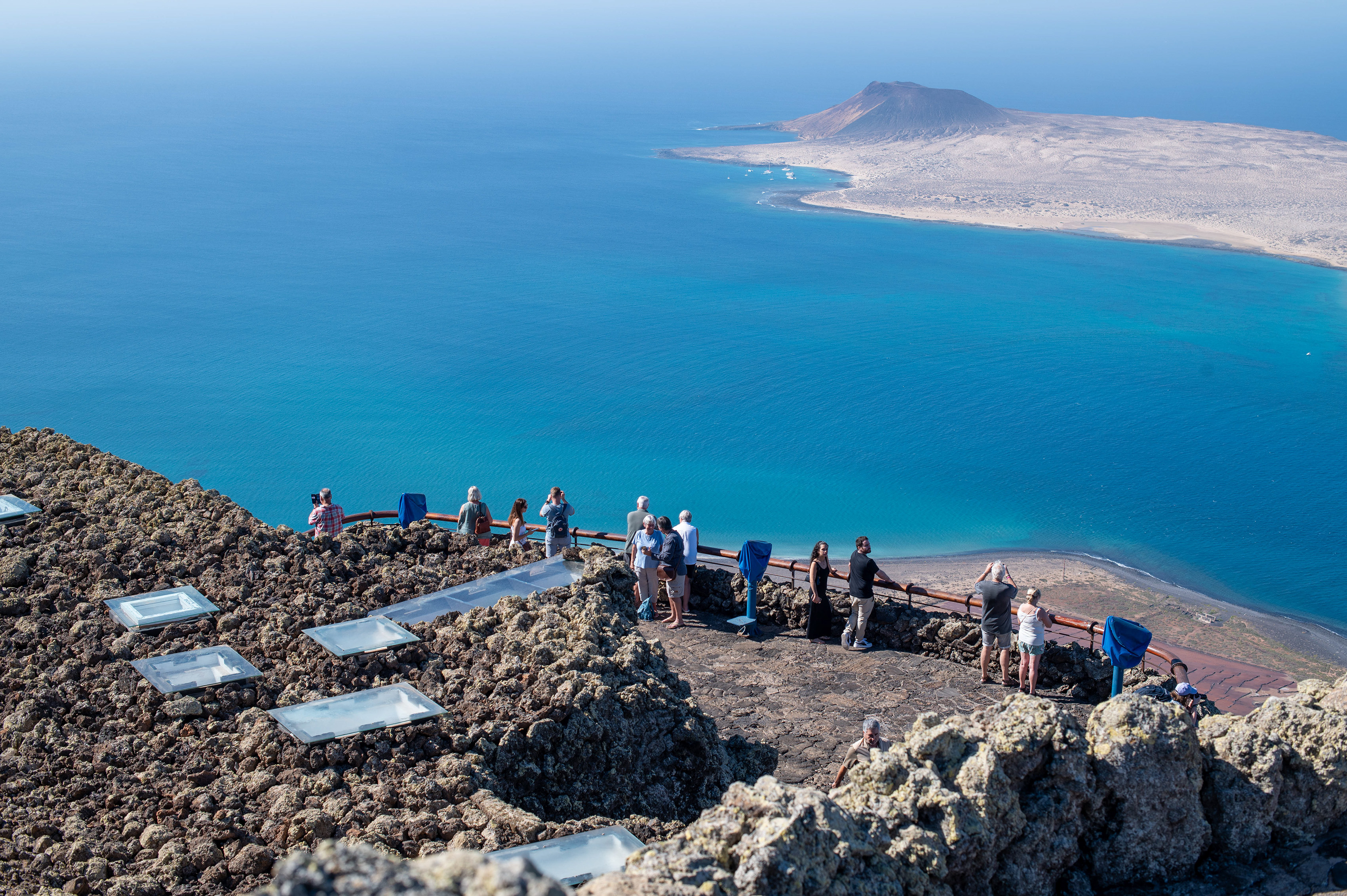 a beautiful coastal area with clear blue waters and a volcanic landscape