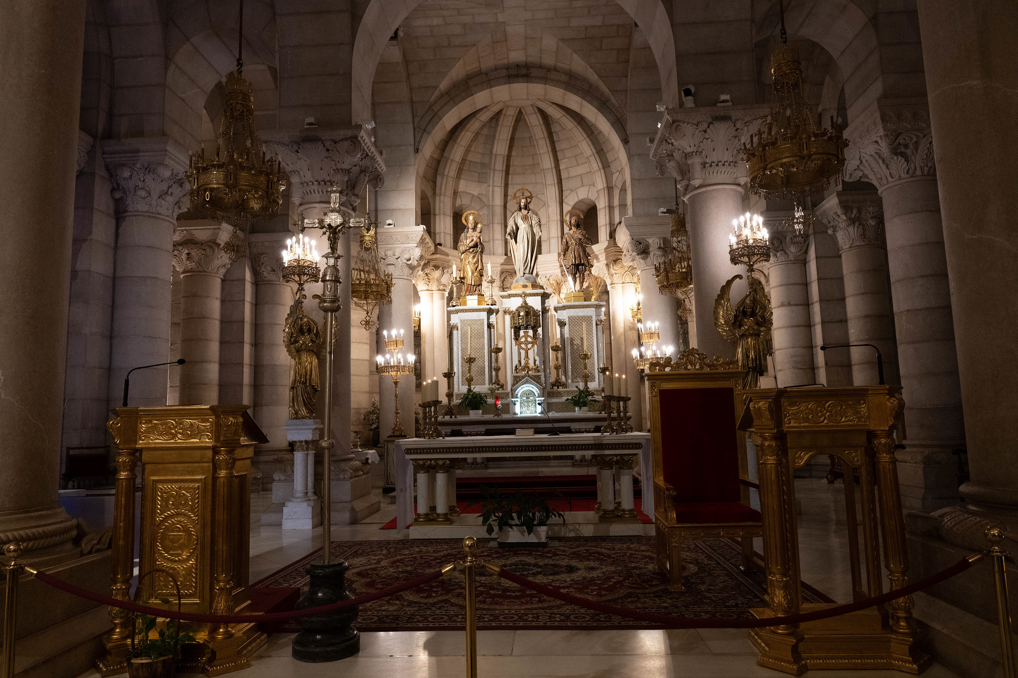 illuminated by numerous candles and chandeliers, creating a warm and reverent atmosphere