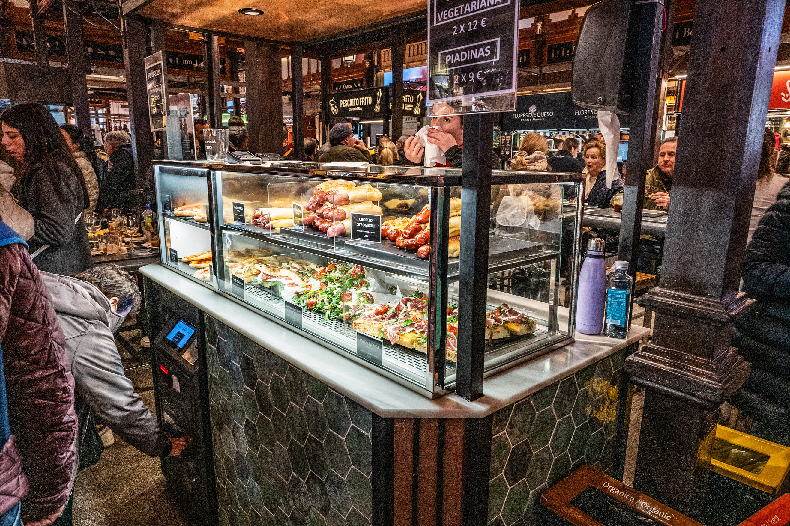 gathered around a counter displaying a variety of food