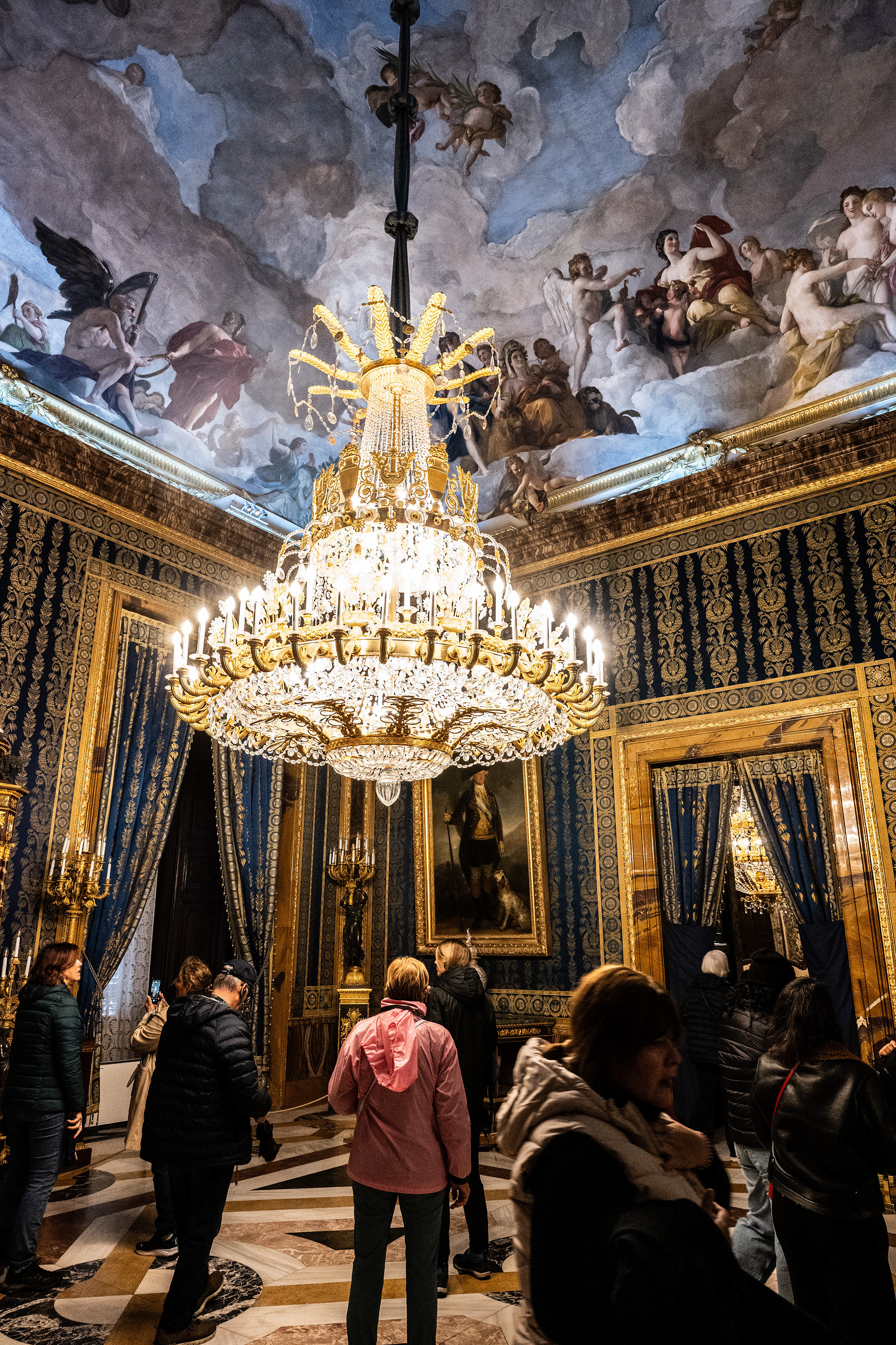 The walls are covered in rich, dark blue and gold patterned wallpaper