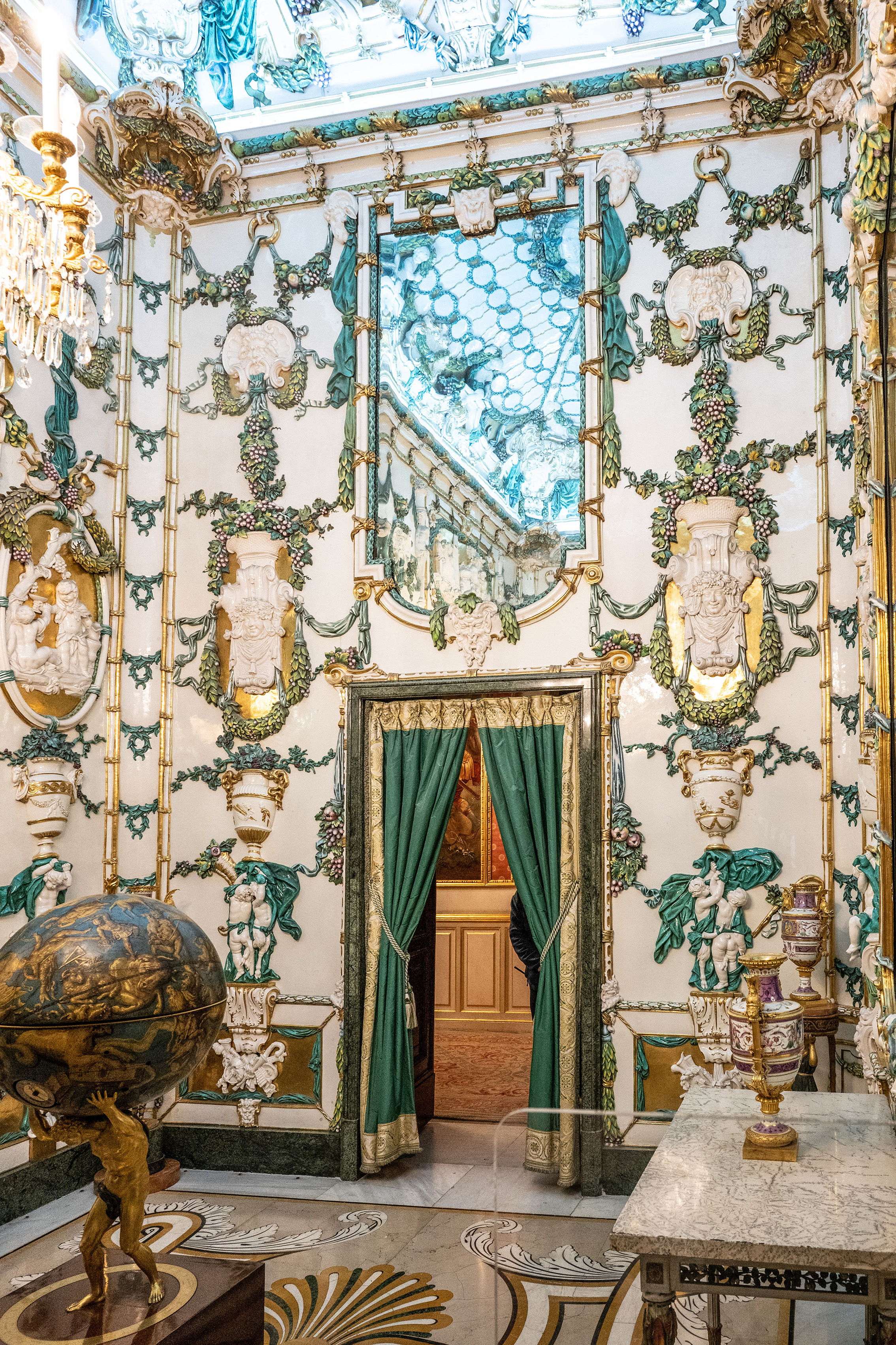 intricate stucco work, ornate moldings, and elaborate decorations in gold and pastel colors