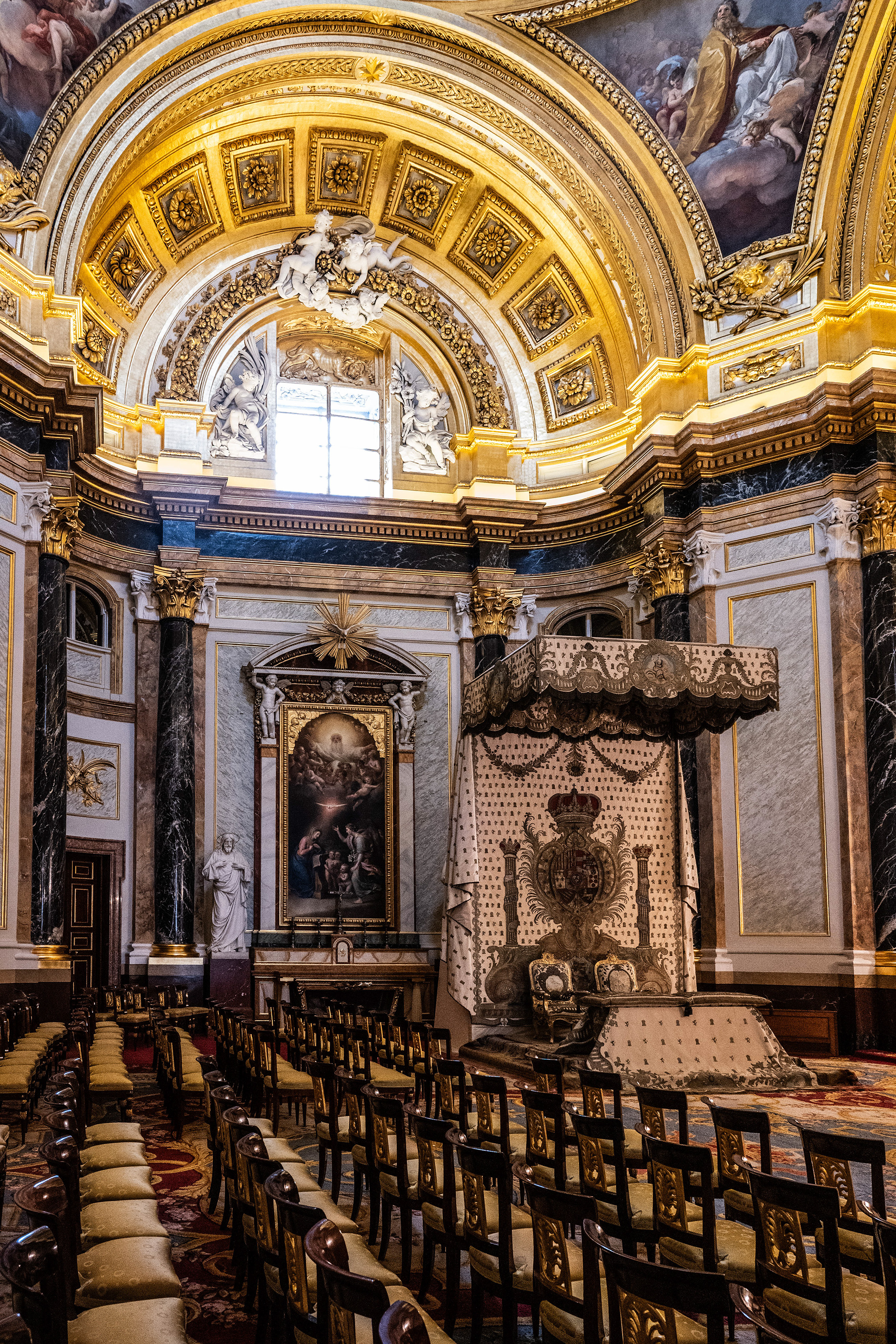 The ceiling features intricate gold detailing and frescoes