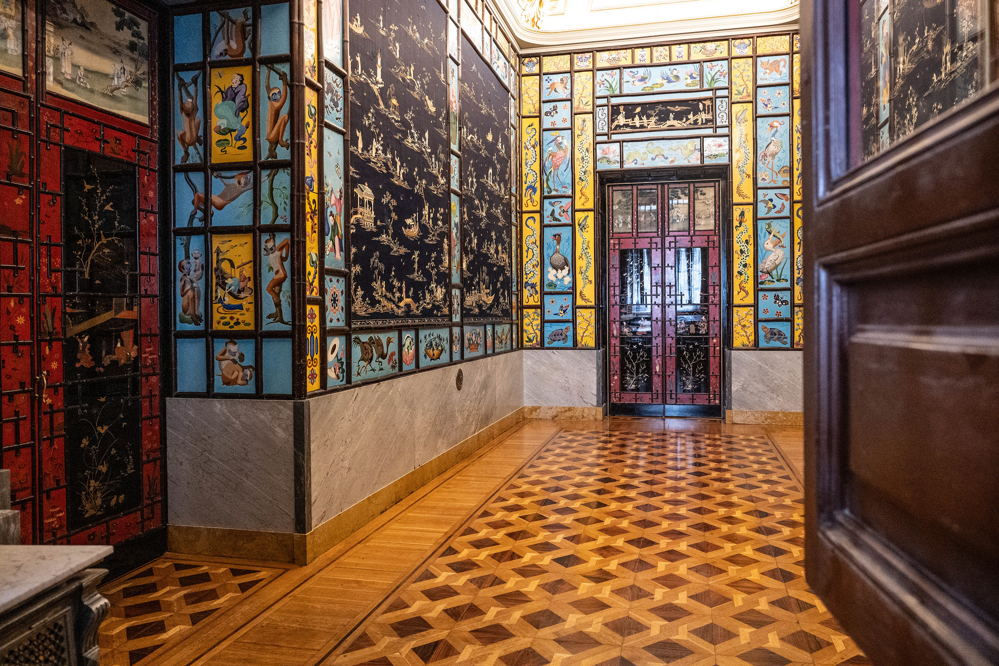 a richly decorated hallway with intricate tile work on the walls