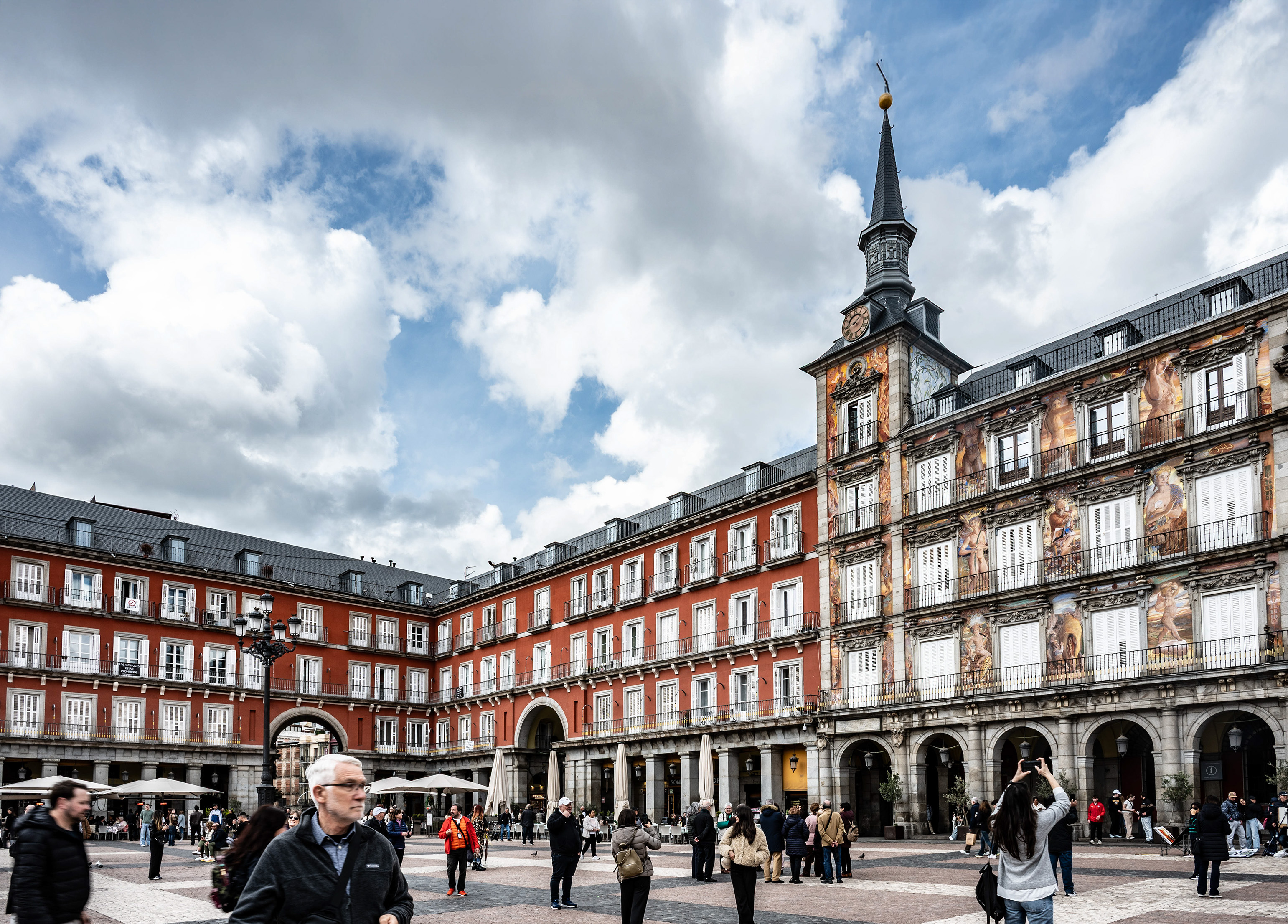 public square characterized by its distinctive red buildings with balconies adorned with statues