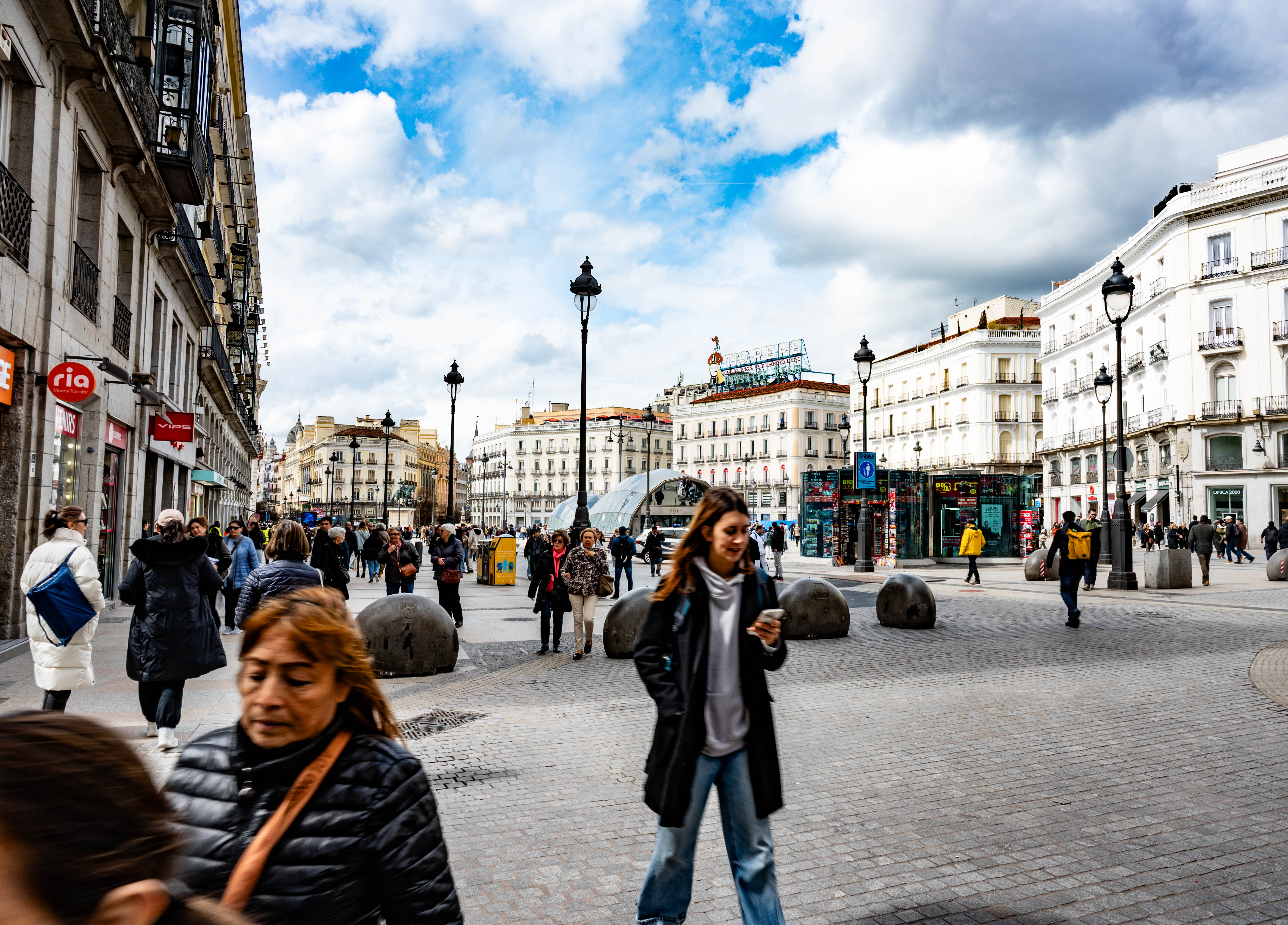 numerous pedestrians walking through a plaza