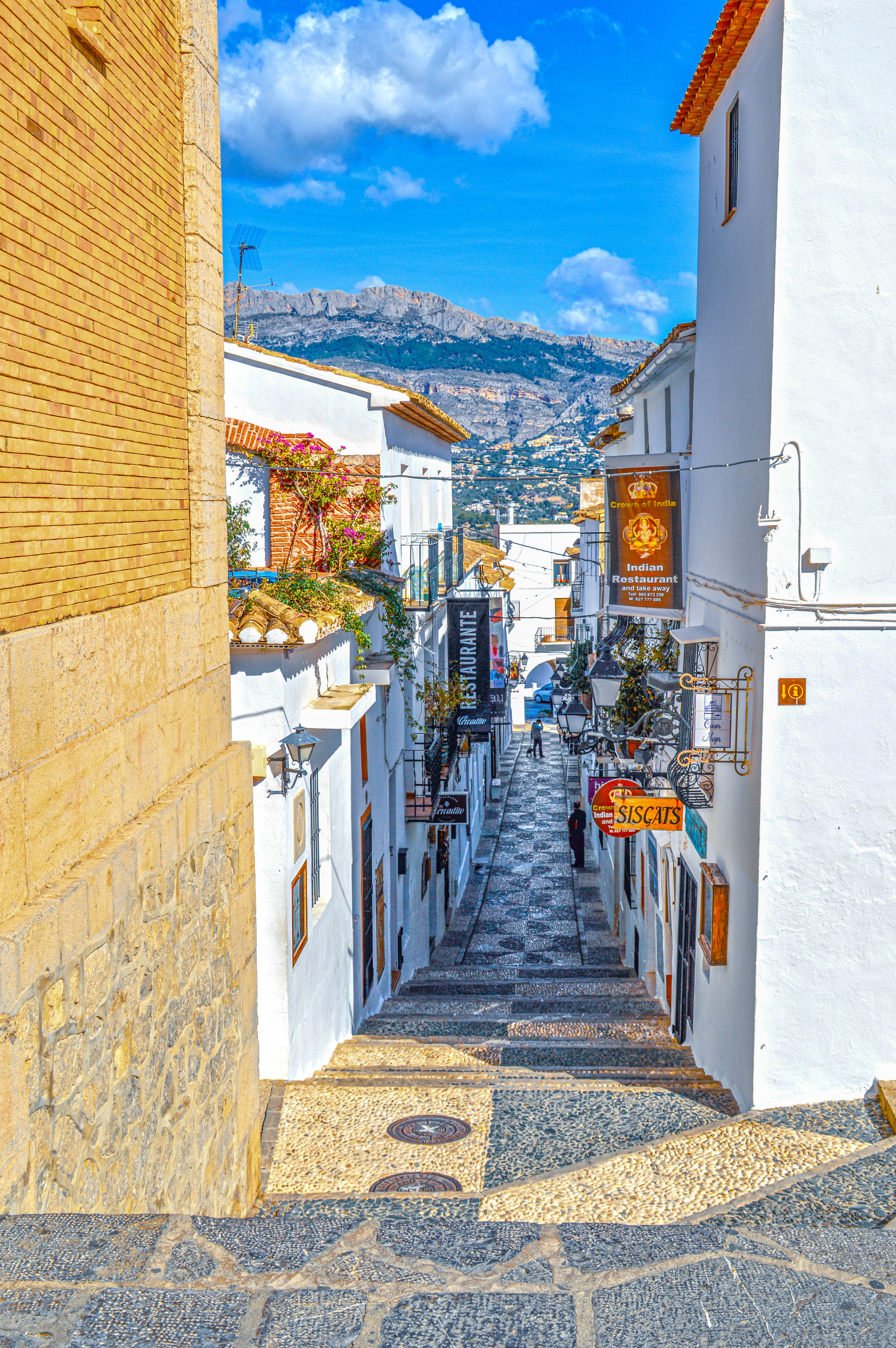 whitewashed buildings adorned with vibrant flowers and traditional tiles