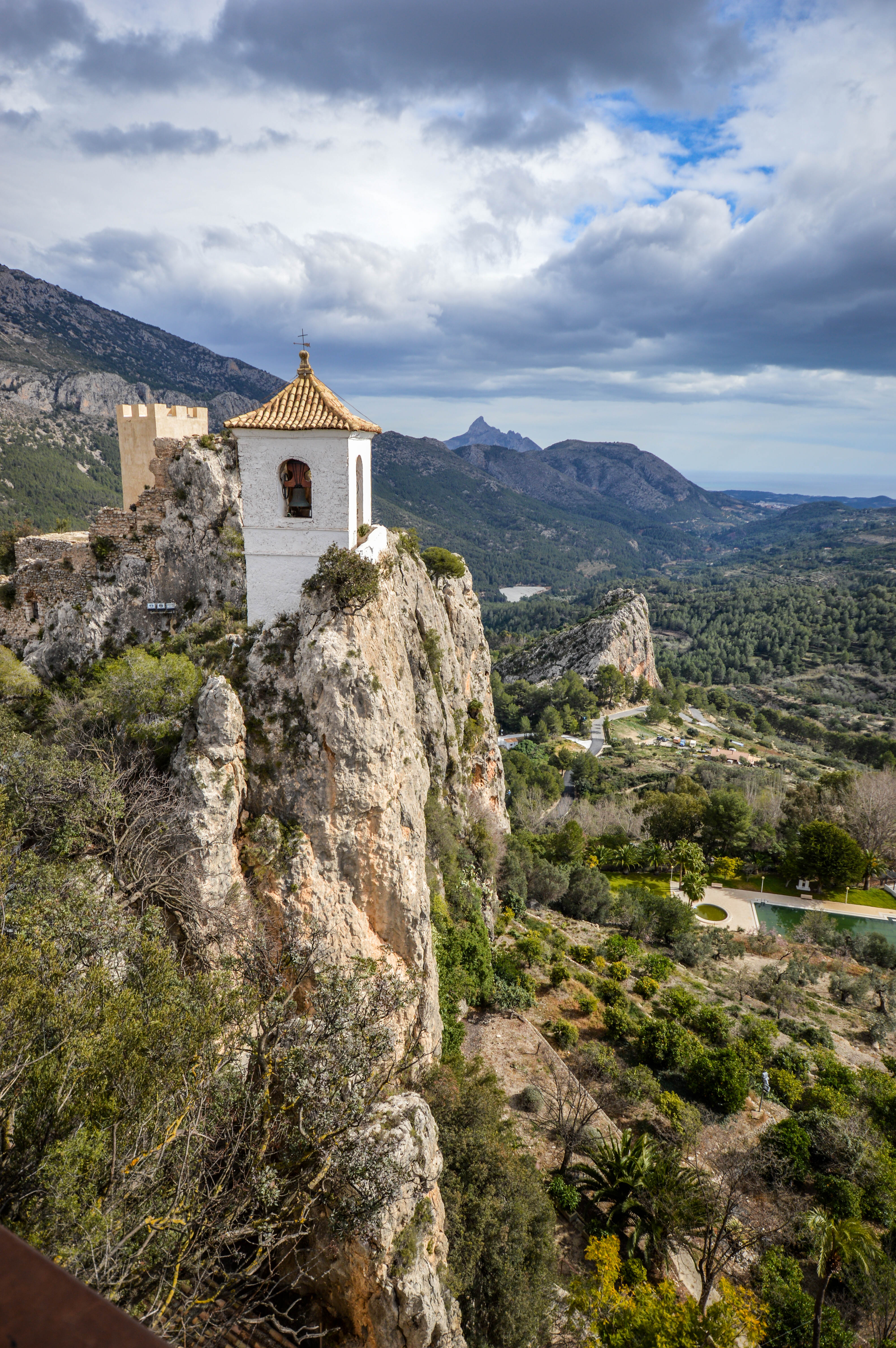 a small white chapel perched on a rocky cliff