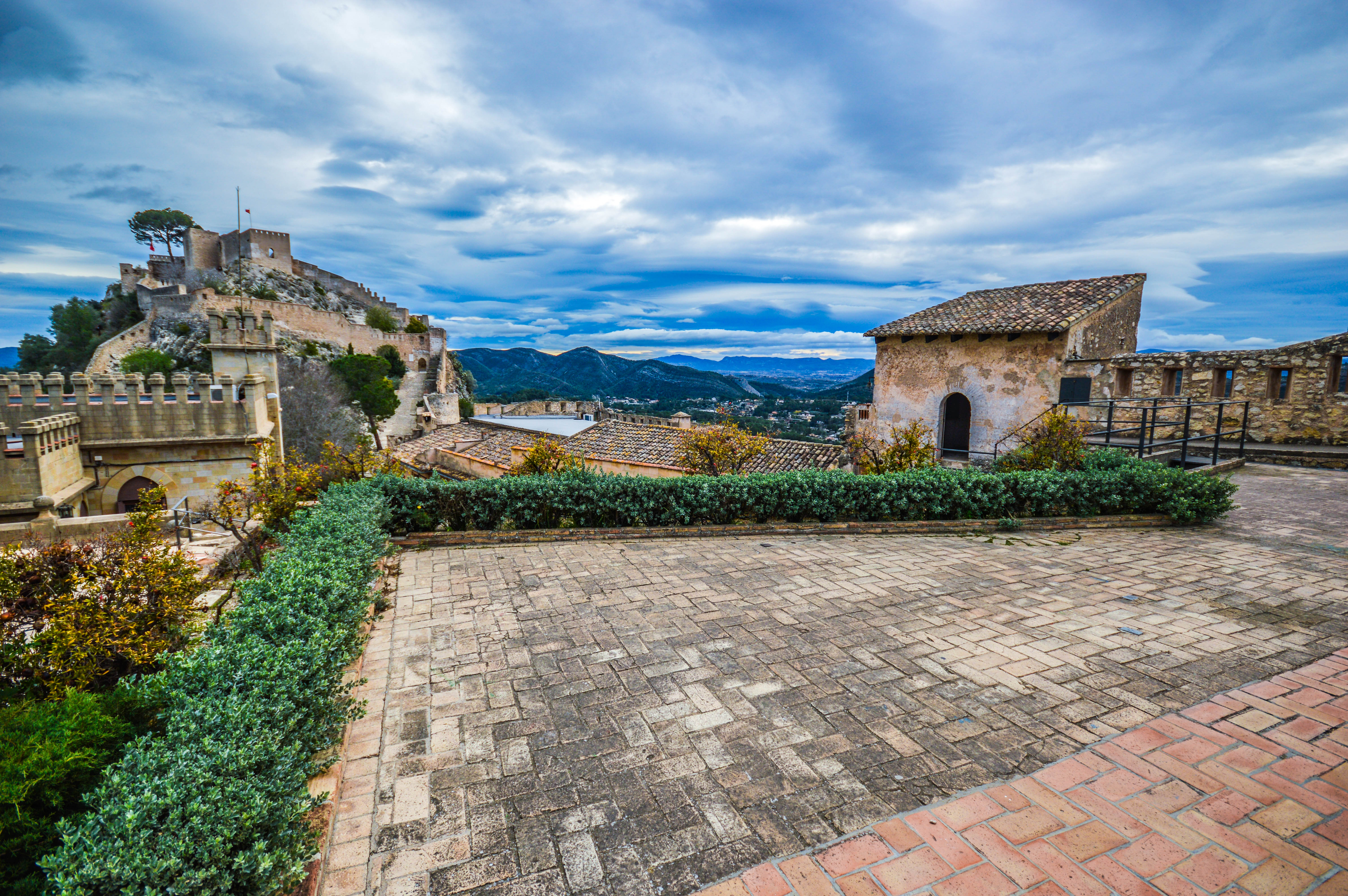 scenic view of a historic castle with stone walls and towers, set against a backdrop of rolling hills