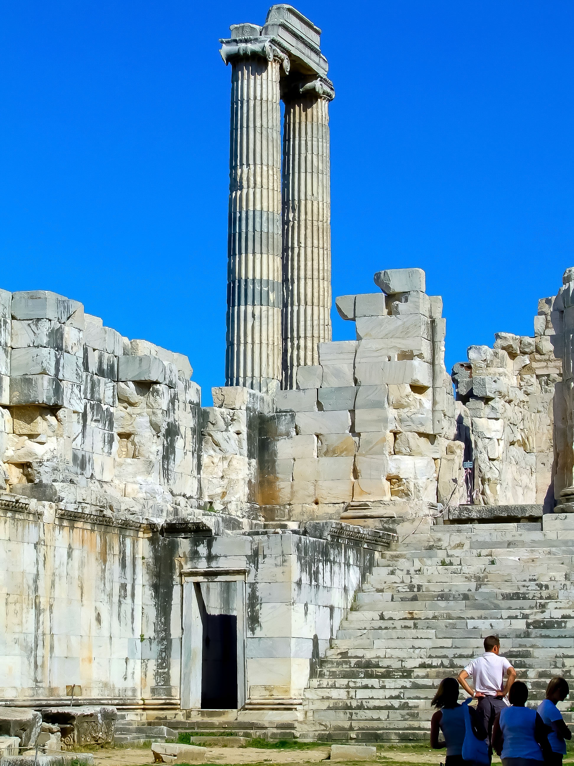 steps leading up to an entrance, and the remnants of an architrave and columns are visible