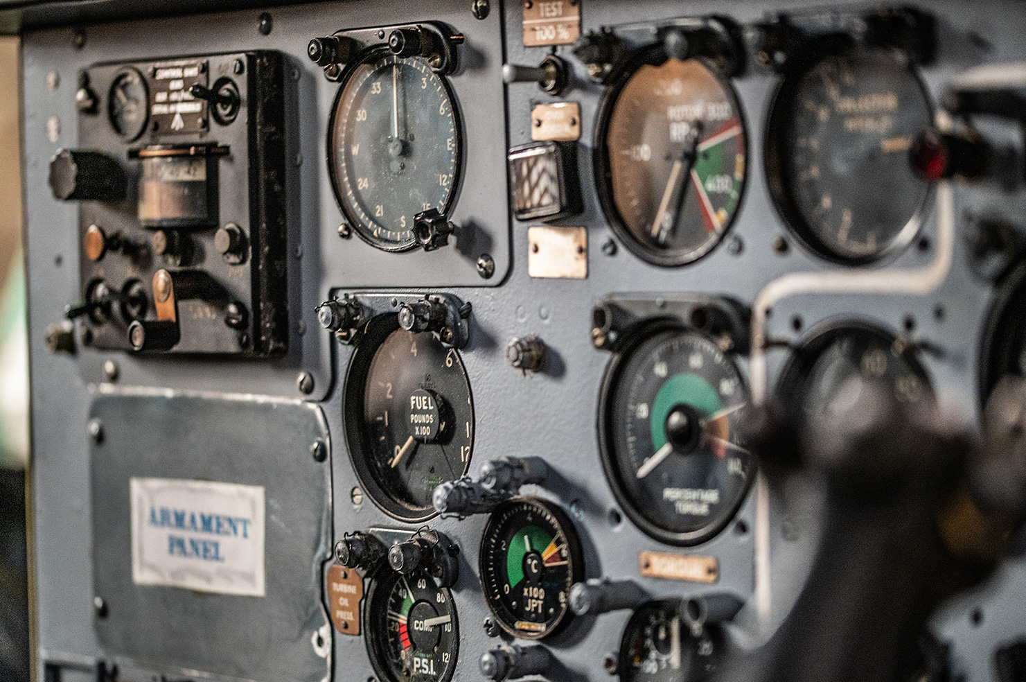 The image shows a close-up of an aircraft's armament panel, featuring various gauges and dials. These include instruments for measuring fuel levels, pressure, temperature, and other critical flight data. The panel appears to be from an older aircraft, given the analog nature of the gauges and the overall design. The labels and markings on the dials provide specific measurements and operational statuses. This panel is essential for monitoring and controlling the aircraft's armament and related systems during flight.