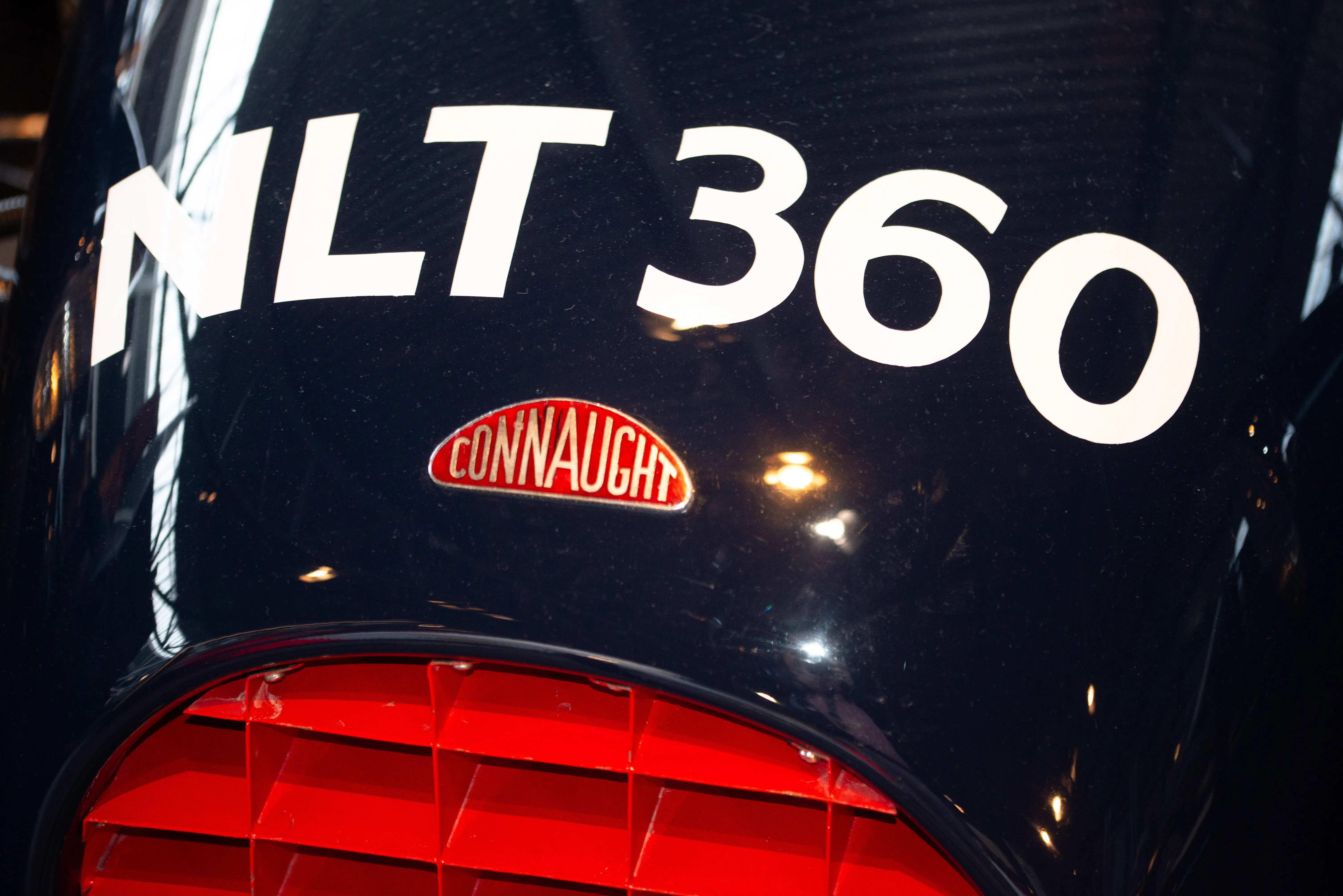 The image shows a close-up of a black motorcycle tank with the text 'MLT 360' prominently displayed in white. Below this text, there is a red oval logo with the word 'Connaught' written in white.