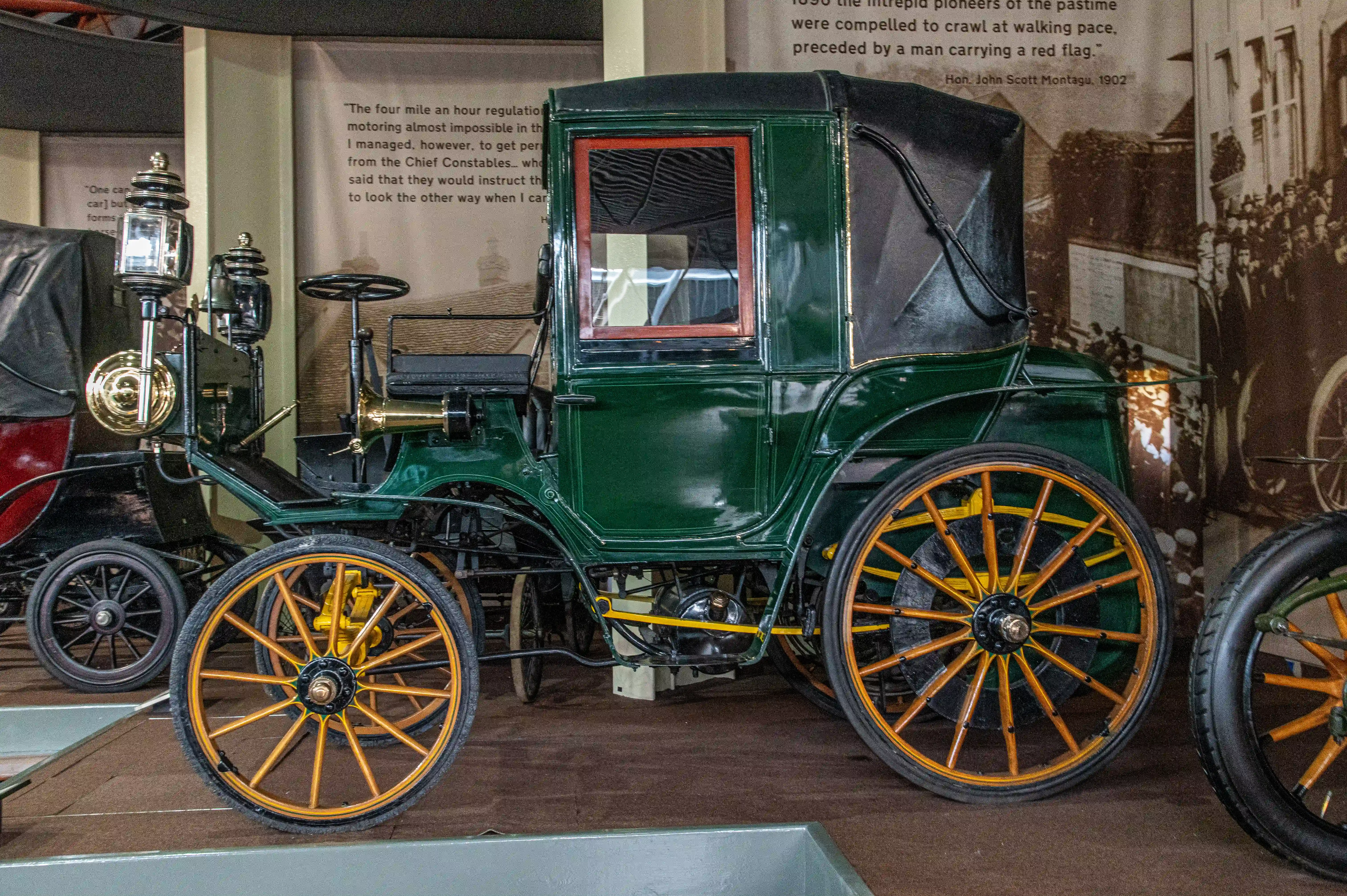 The document describes the early challenges of motoring, including a strict speed limit of four miles per hour and the requirement for a man to walk ahead with a red flag. It mentions the difficulty of navigating around horse-drawn carriages and the need to obtain special permission from authorities to drive. The text highlights the pioneering spirit of early motorists and the humorous anecdote of a driver who managed to secure permission to drive by bribing officials to look the other way.