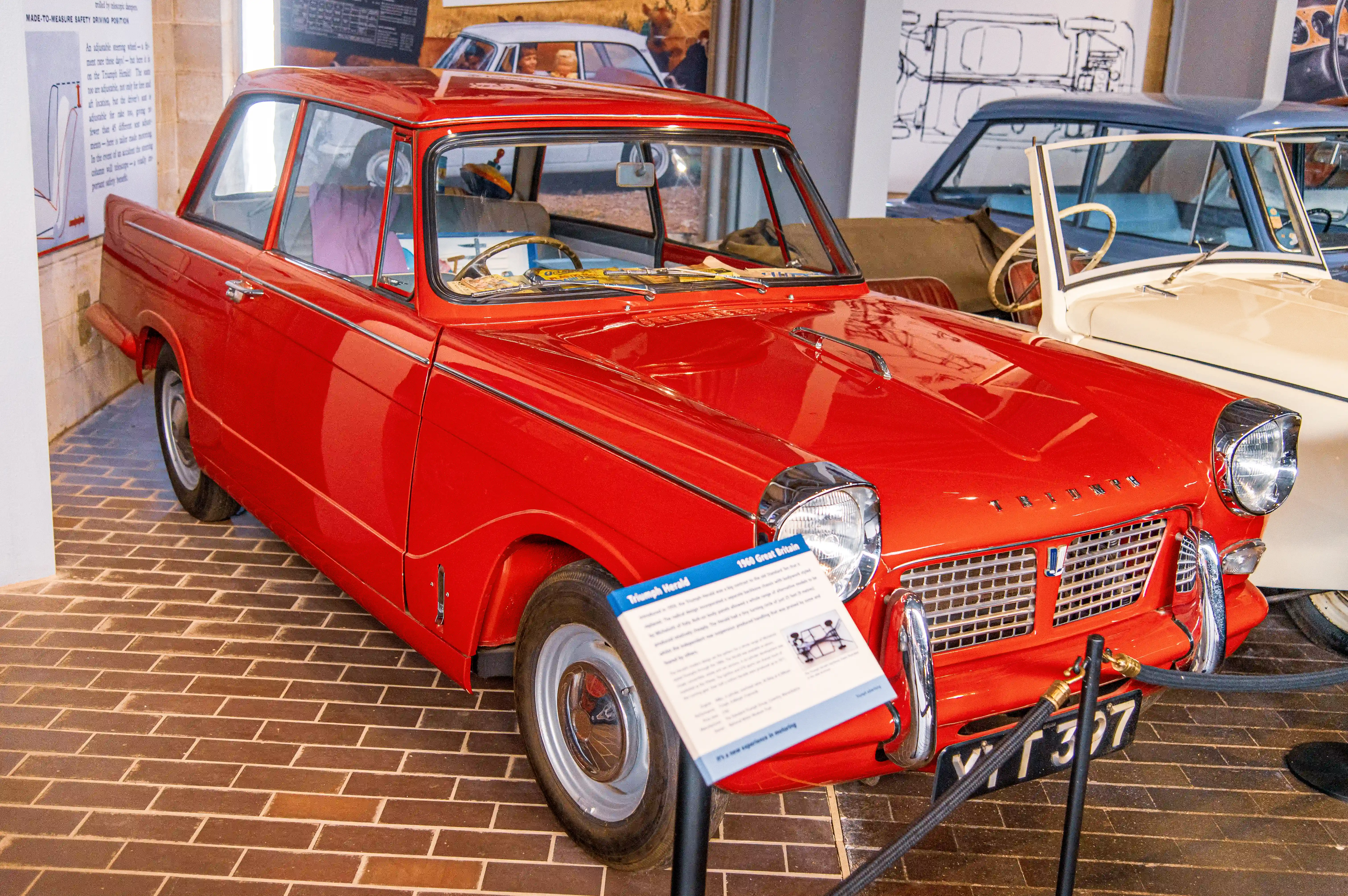 The document describes a classic car exhibition featuring a red Triumph Herald 12/70 from 1961. The car is noted for its distinctive design, including a curved roof and chrome bumpers. The exhibition highlights the car's features and historical significance, with an emphasis on the vehicle's role in automotive history. Visitors can view the car and read detailed information about its specifications and design elements.