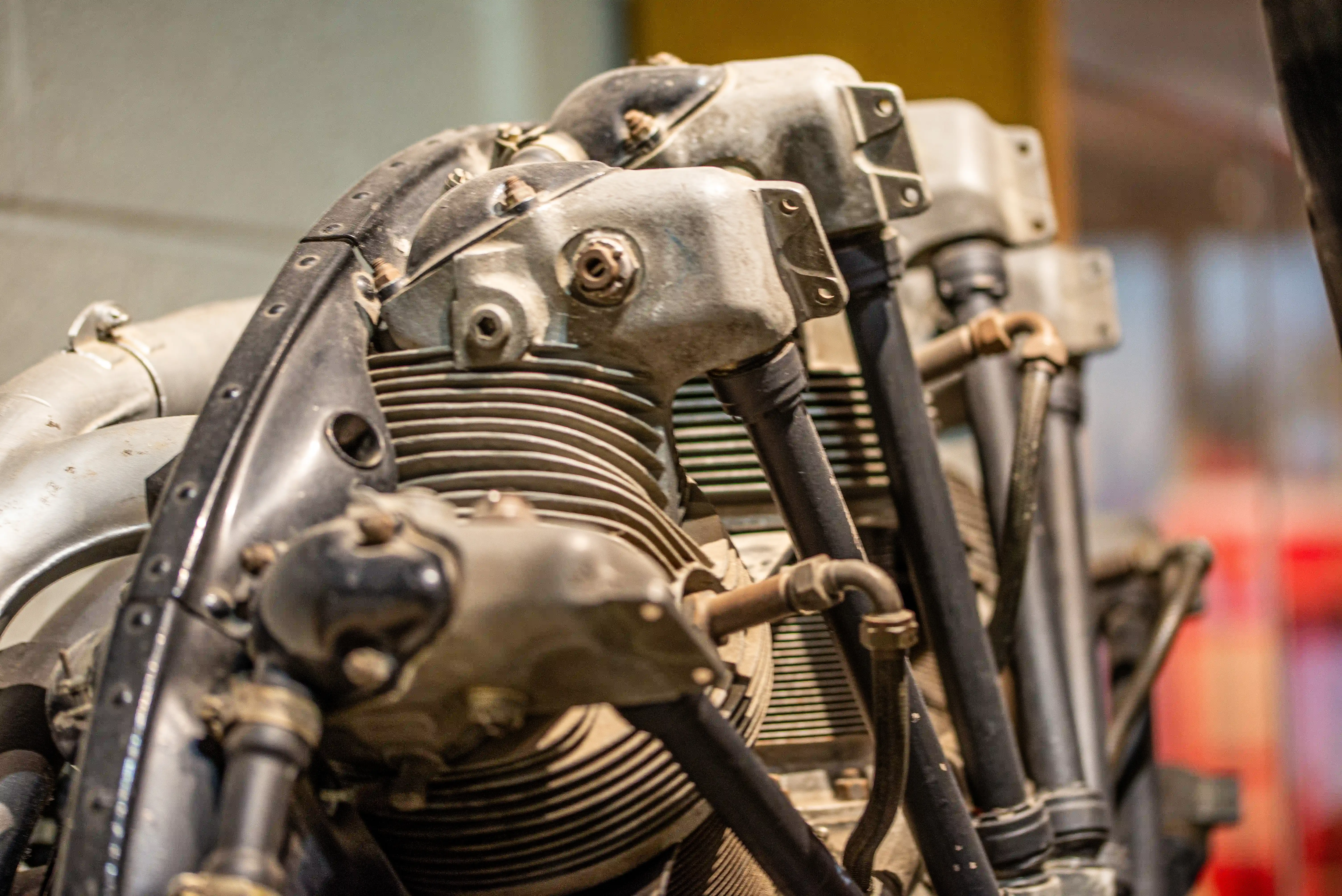 Close-up view of a grey and silver vintage radial aircraft engine's cylinders and associated metal parts.