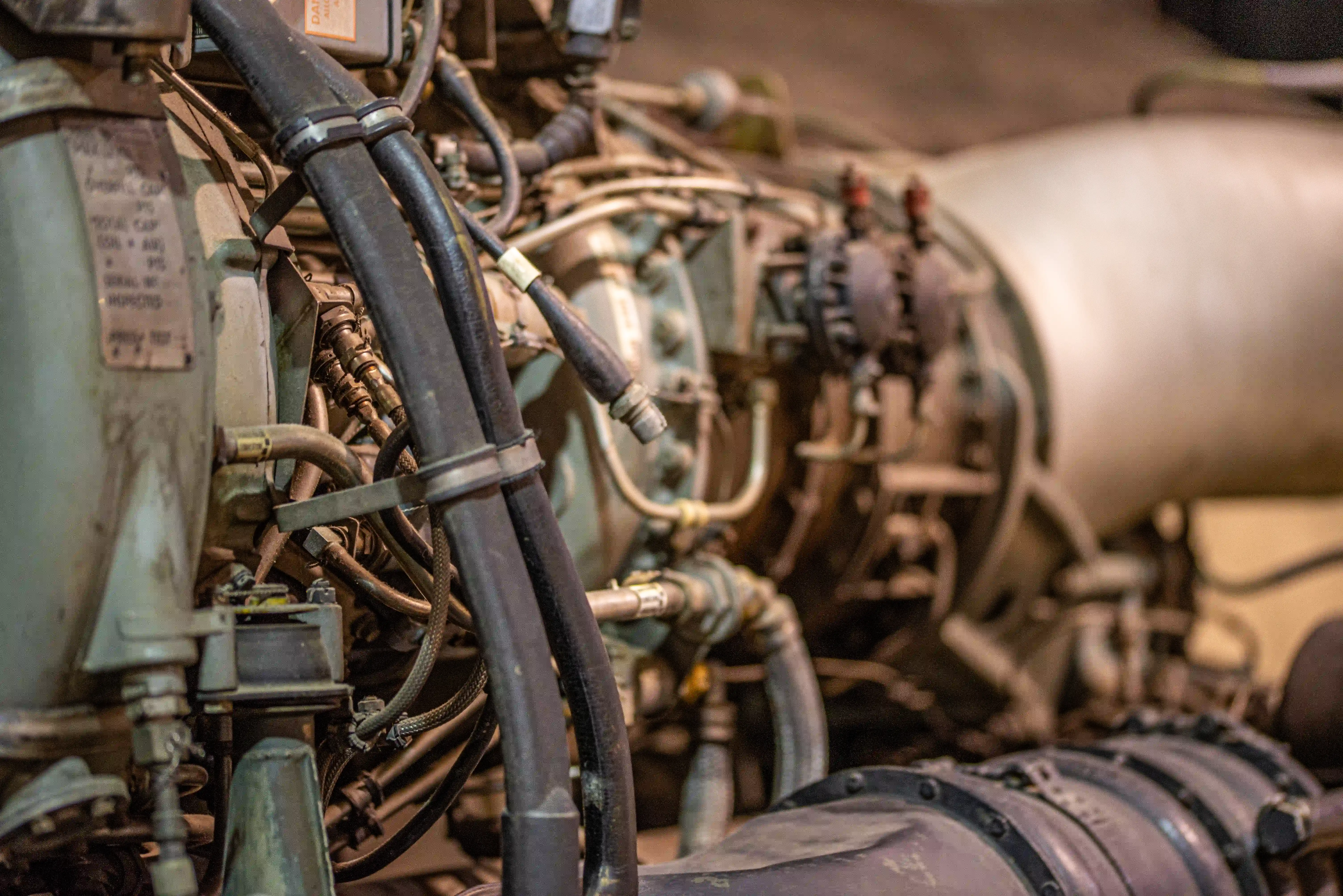 Detailed view of the intricate network of hoses, pipes, and mechanical components within a jet engine.