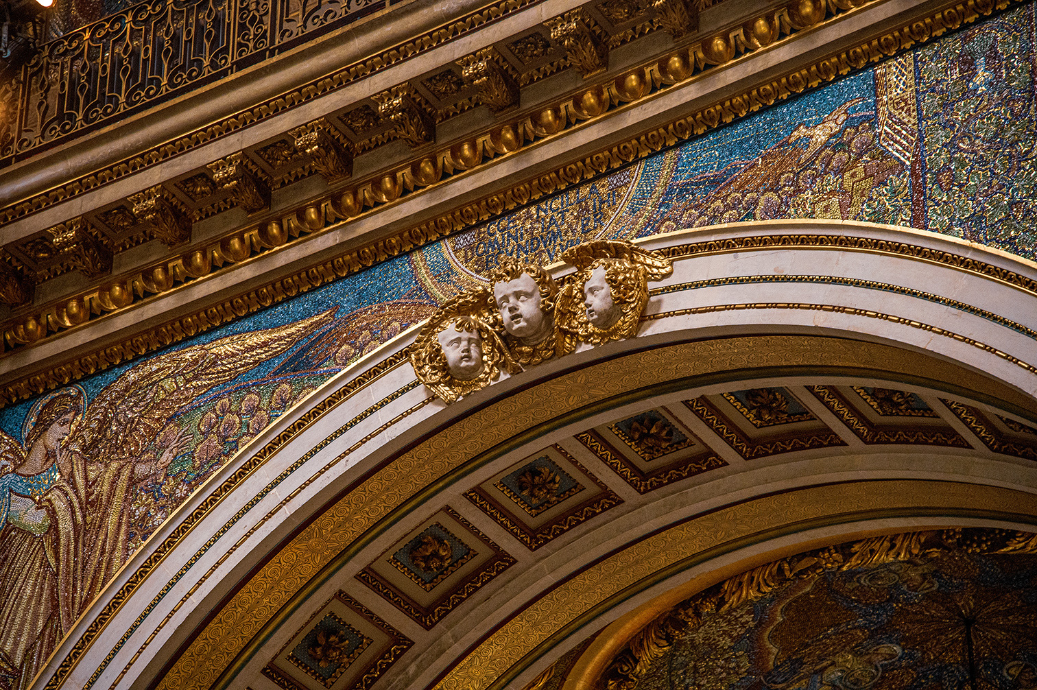 The image showcases an ornate interior featuring intricate gold and blue mosaics, detailed carvings, and classical architectural elements, including arches and decorative moldings.