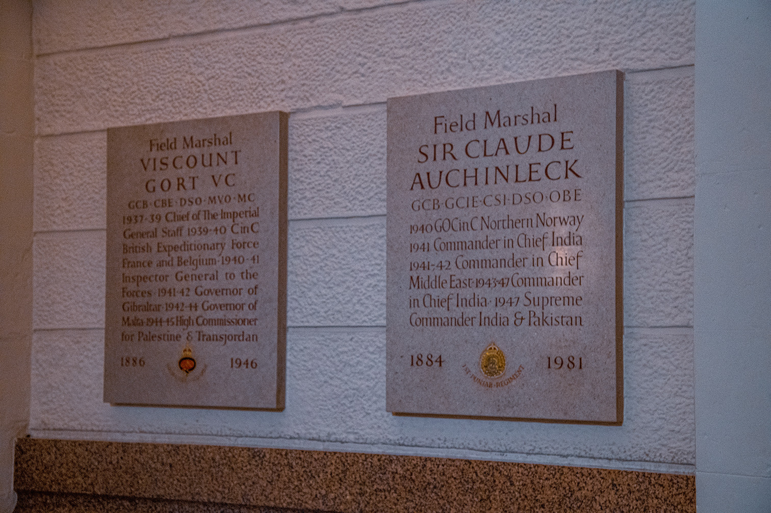 The image shows two plaques commemorating two prominent military figures. The first plaque is for Field Marshal Viscount Gort VC, detailing his roles and achievements from 1937 to 1945, including positions such as Chief of the Imperial General Staff, Governor of Gibraltar and Malta, and High Commissioner for Palestine and Transjordan. The second plaque is for Field Marshal Sir Claude Auchinleck, listing his roles and achievements from 1940 to 1947, including positions such as Commander in Chief in India and the Middle East, and Supreme Commander of India and Pakistan.