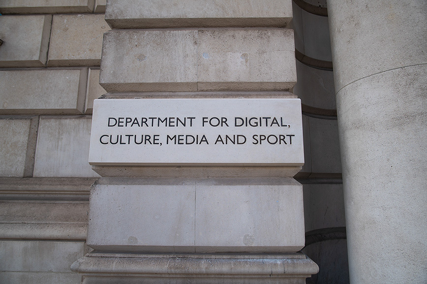 The image shows a stone plaque mounted on a stone wall. The plaque reads 'DEPARTMENT FOR DIGITAL, CULTURE, MEDIA AND SPORT'.