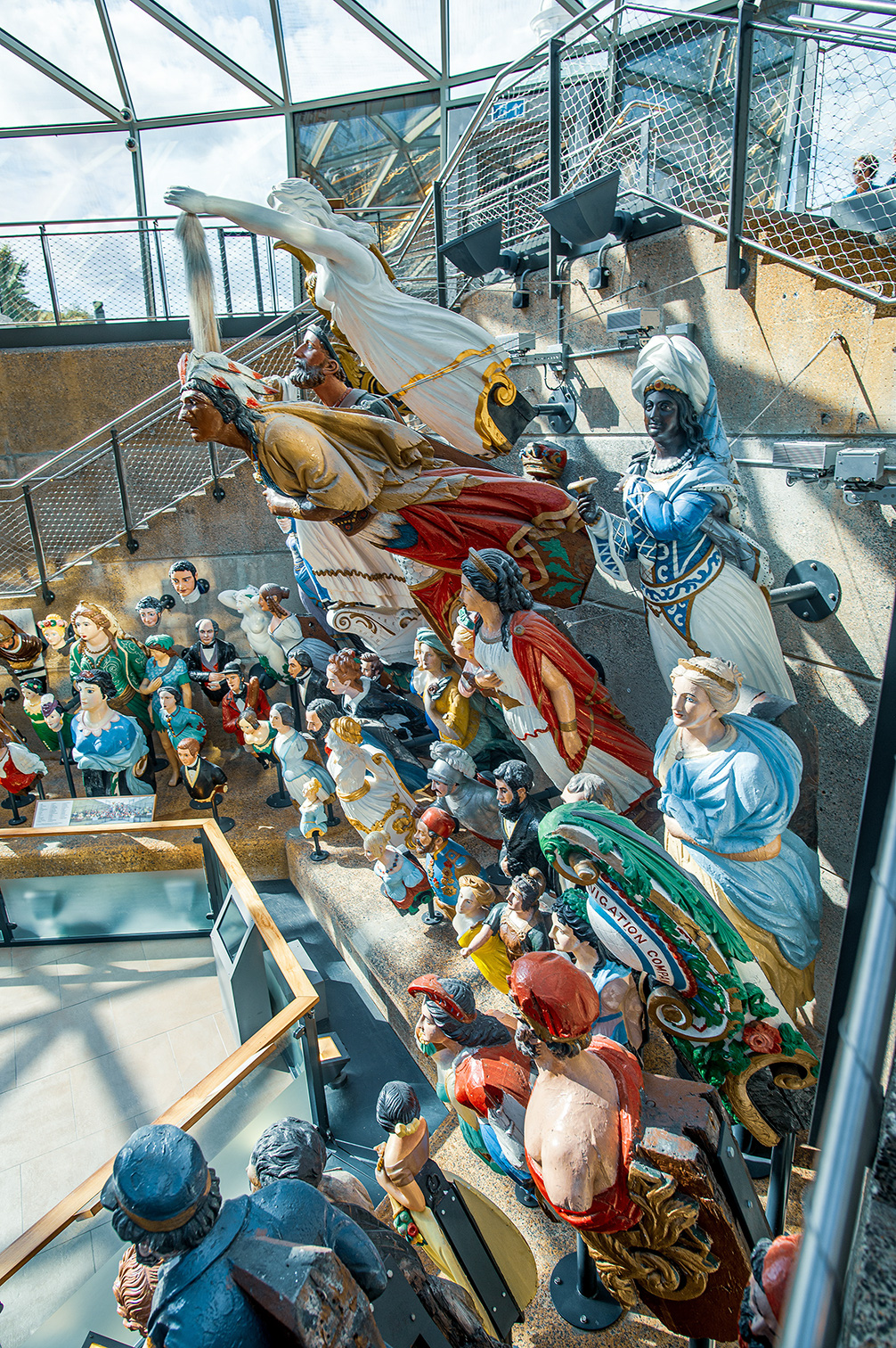 The image depicts a detailed and colorful diorama or scene featuring numerous figurines. The scene appears to be set in a historical or mythological context, with figures dressed in elaborate costumes and engaged in various activities. The setting includes a ship with sails, and the figures are arranged in a dynamic and engaging manner, suggesting a narrative or story being told through the arrangement. The overall atmosphere is vibrant and intricate, capturing the viewer's attention with its detailed craftsmanship and vivid colors.