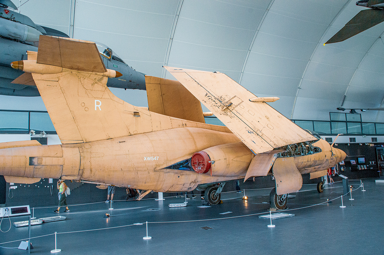 The image shows a military aircraft on display in a museum. The aircraft, marked with the tail number XW547 and the letter 'R', appears to be a fighter jet with a distinctive design, featuring twin tails and intakes. The jet is in a static display setting, with ropes and stanchions keeping visitors at a distance. The setting appears to be indoors, with other aircraft visible in the background, suggesting it is part of an aviation or military museum exhibit.