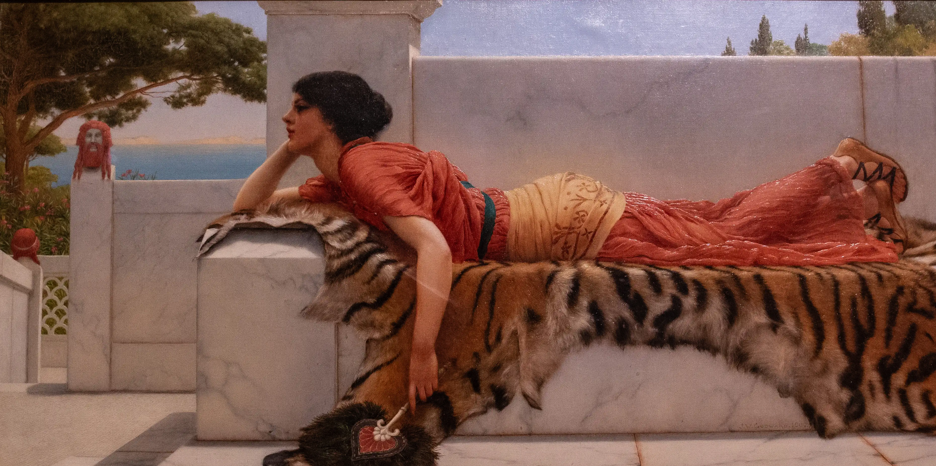 Costumed woman reclining on a patterned fur rug on an outdoor terrace, with a painted garden backdrop